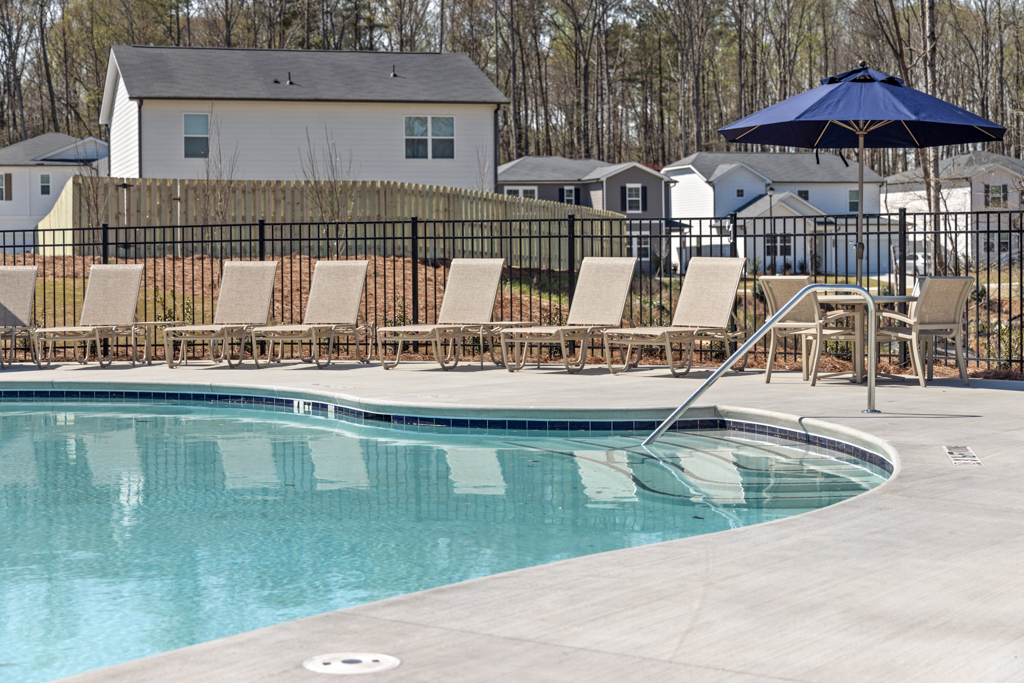 A pool with chairs around it.