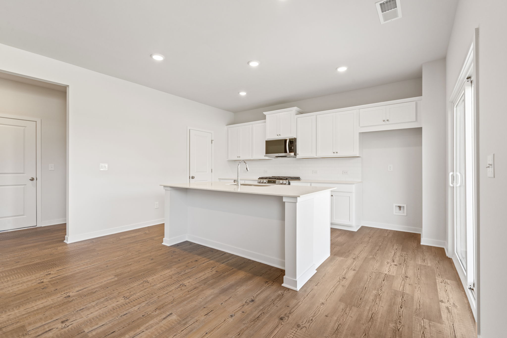 A kitchen with white cabinets.
