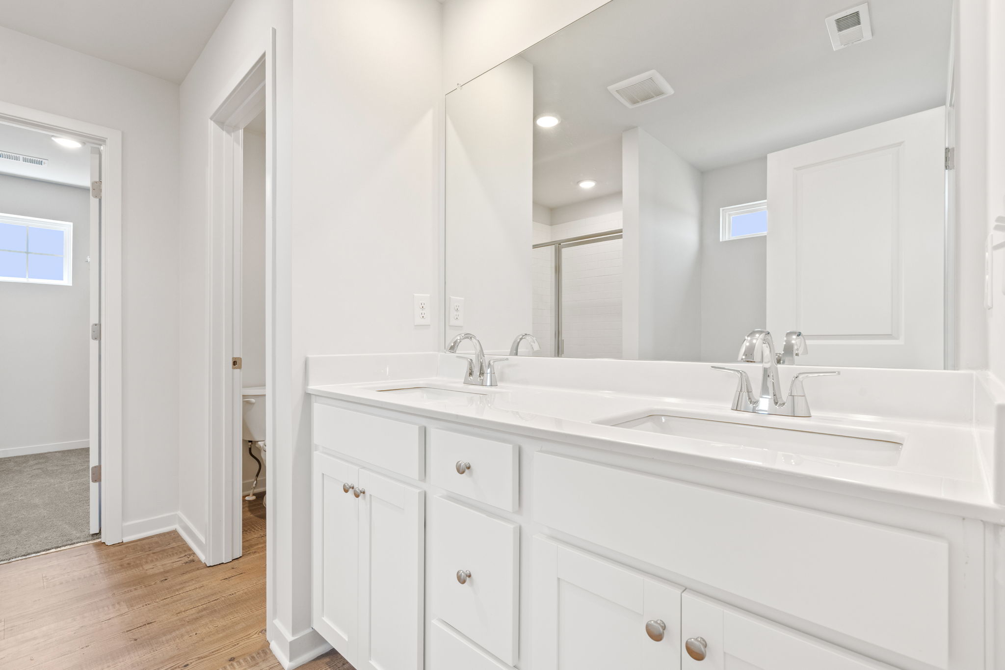 A bathroom with white cabinets.