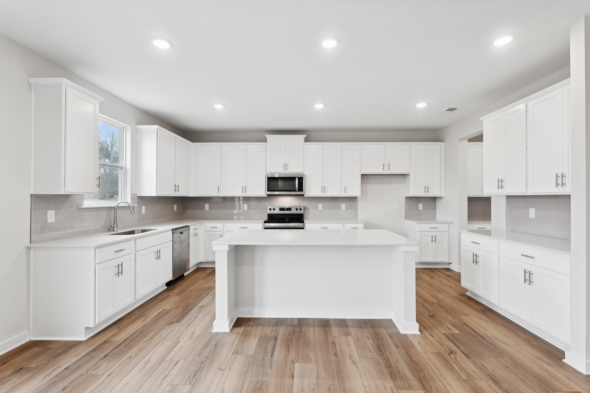 A kitchen with white cabinets.