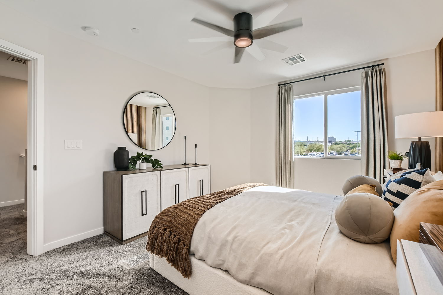 A bedroom with a large mirror.