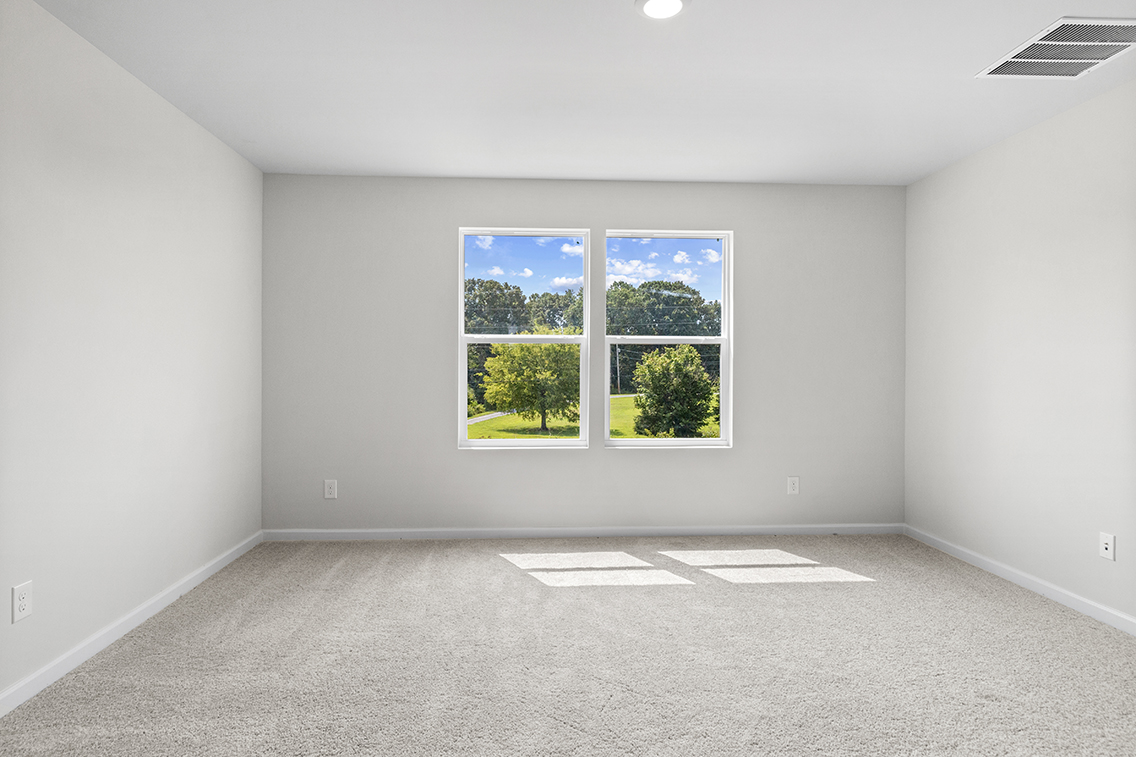 A room with a window and a rug in it.