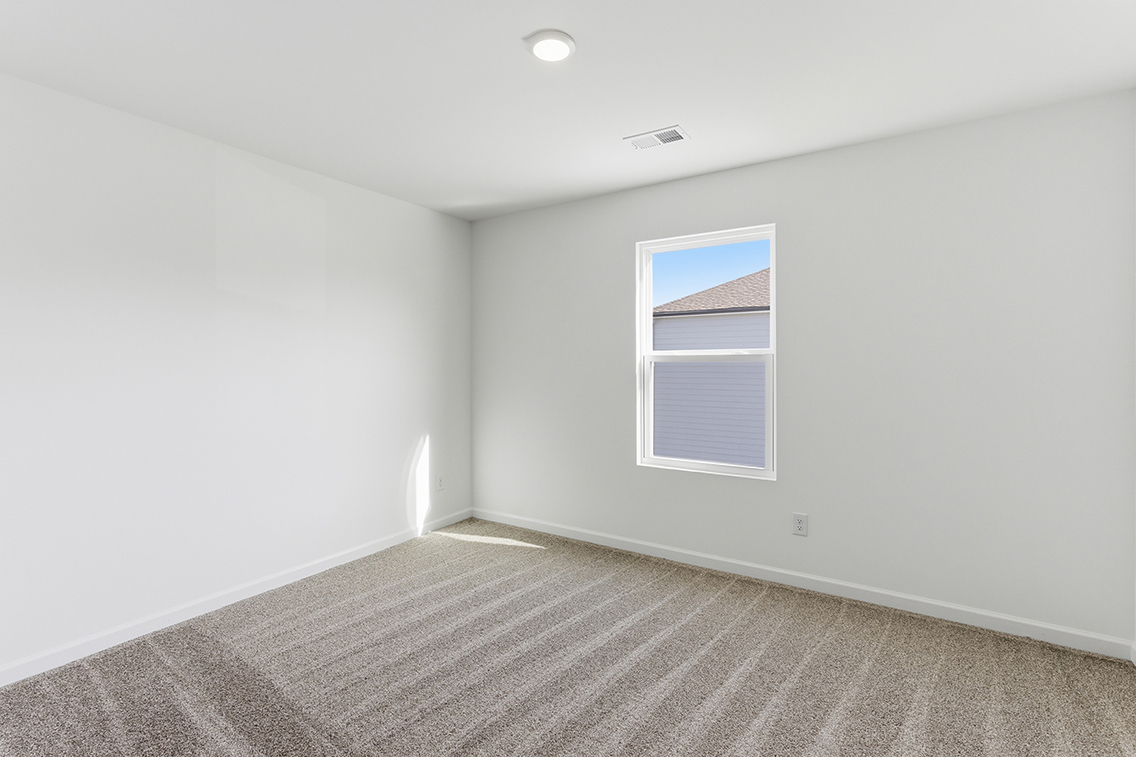 A room with a window and a carpet.