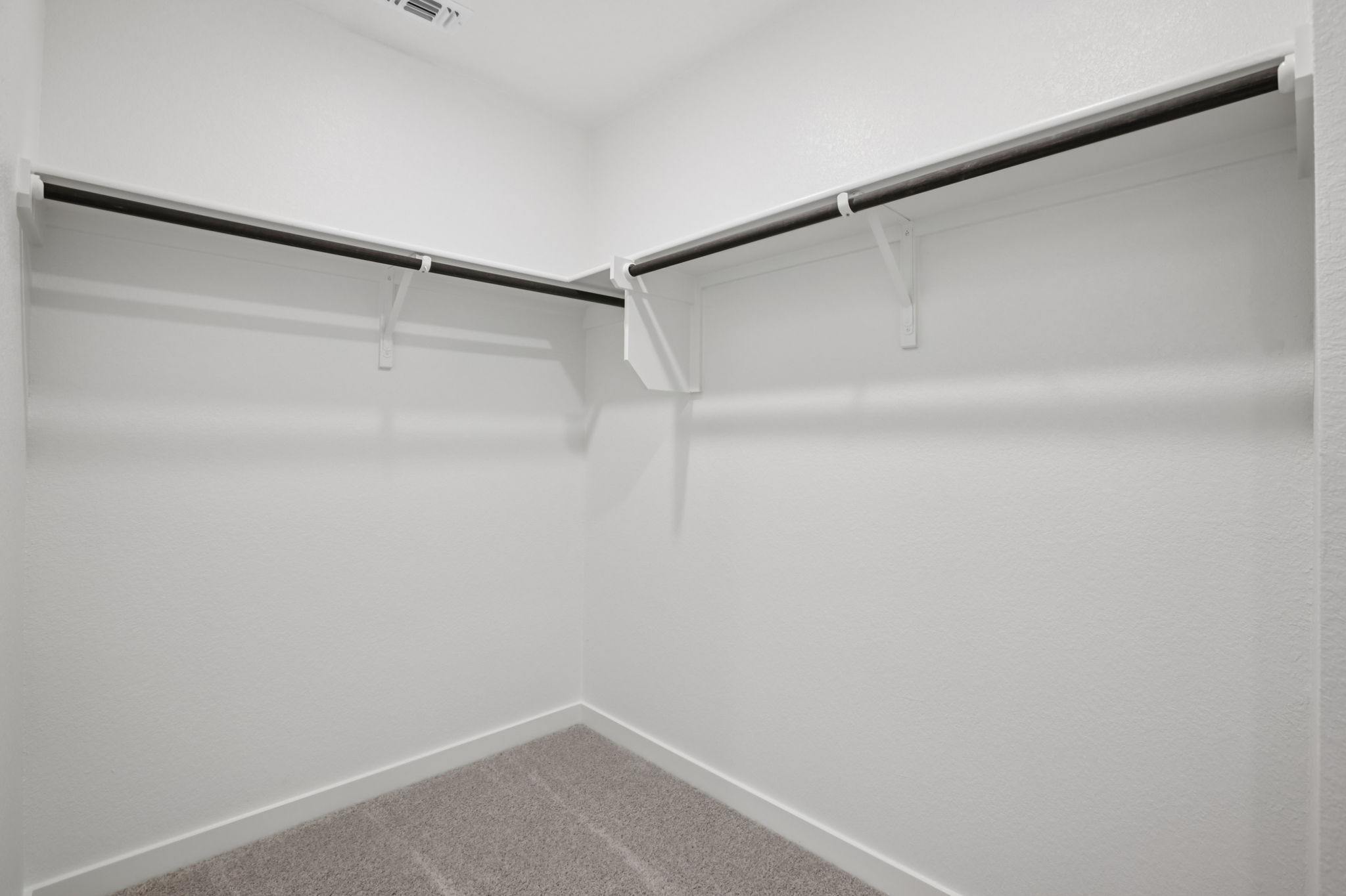 A white wall with a metal bar.