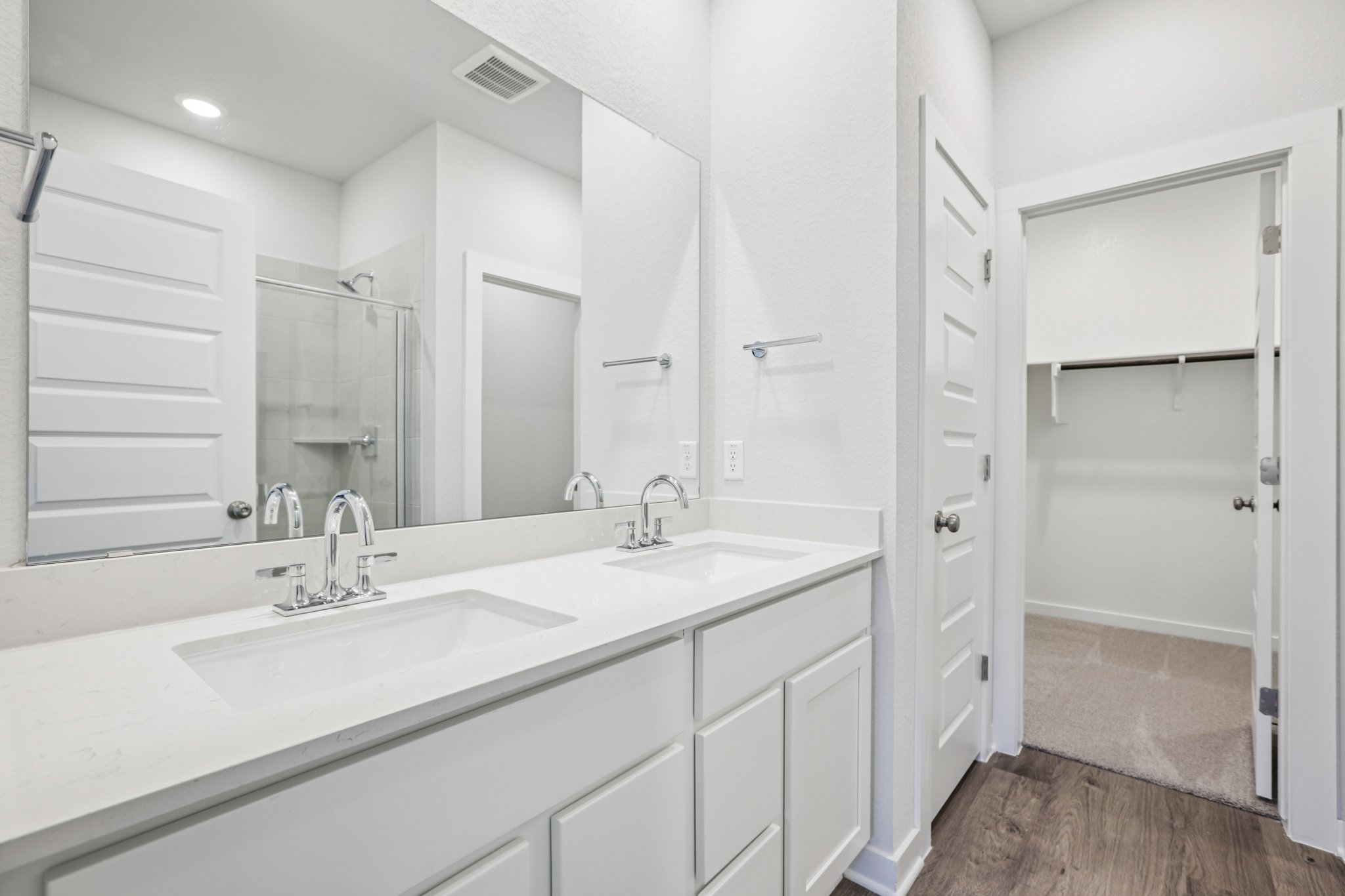 A bathroom with white cabinets.