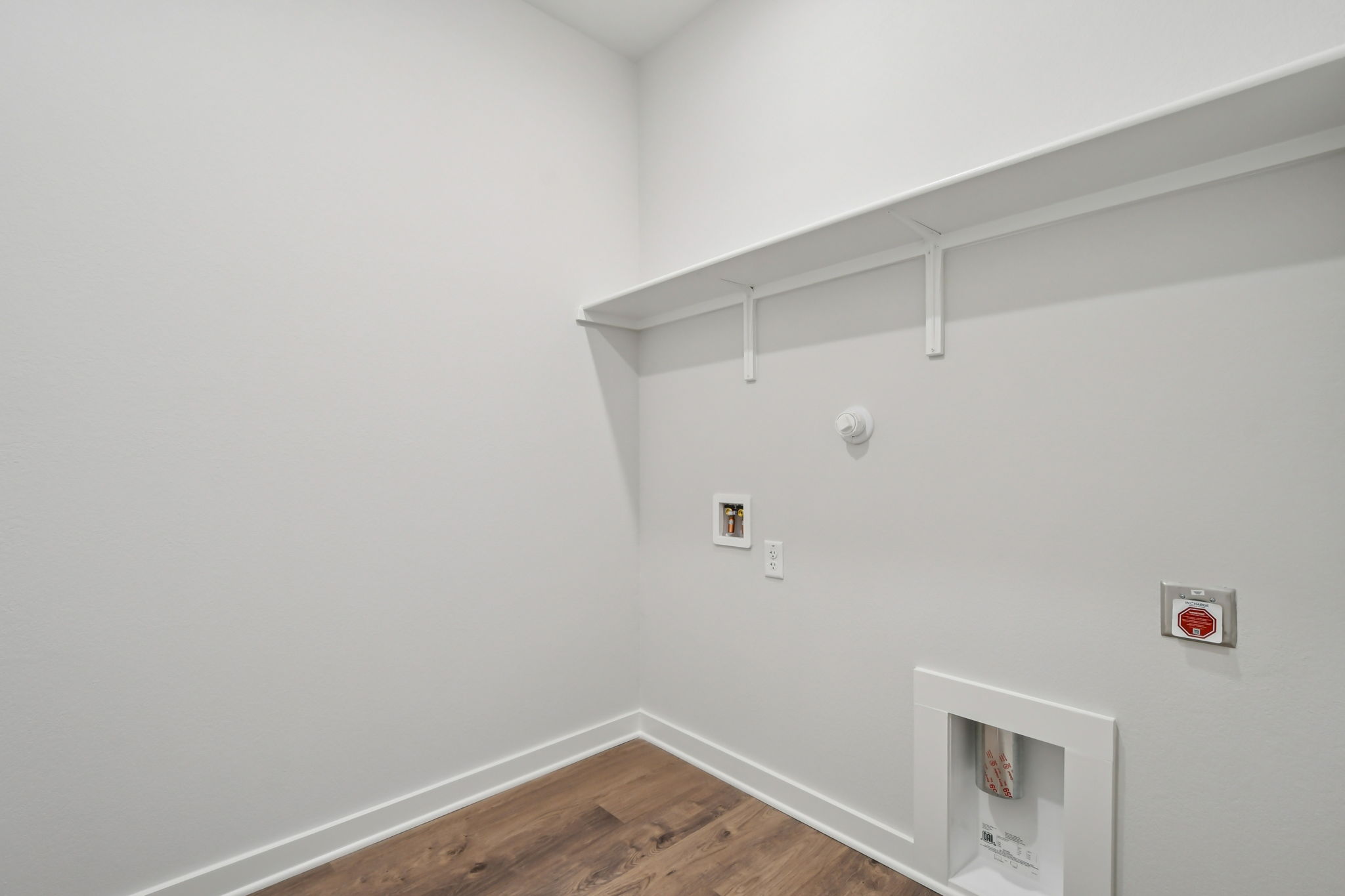 A white room with a wood floor and a white ceiling.