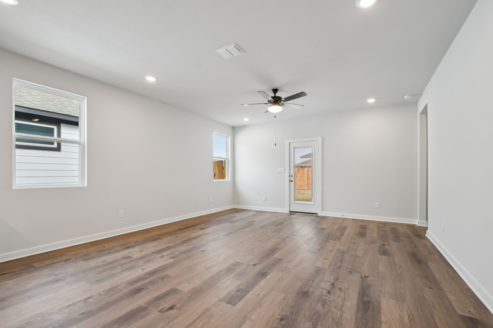 A room with a wood floor and a ceiling fan.