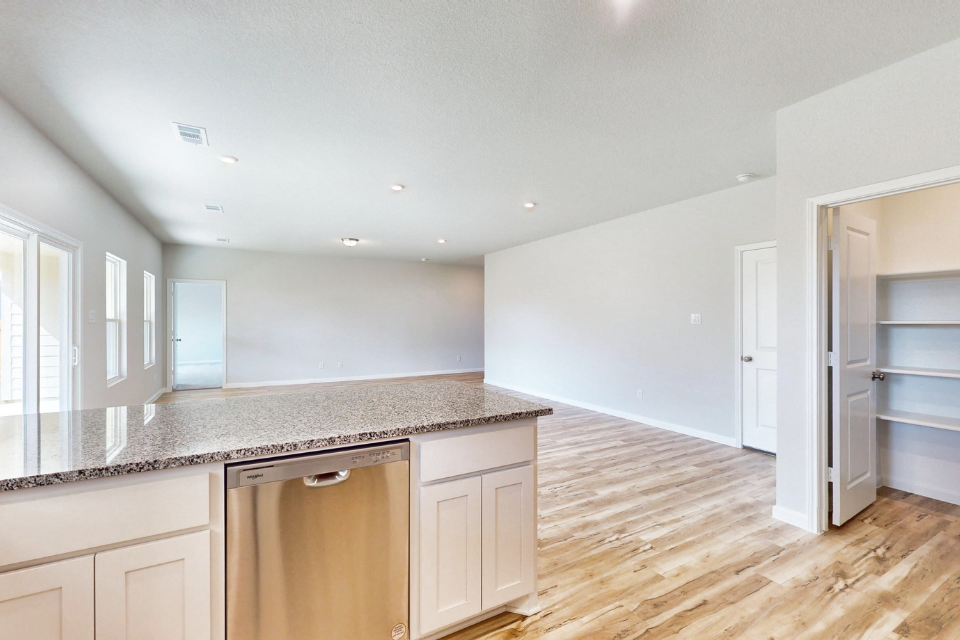 A kitchen with white cabinets.