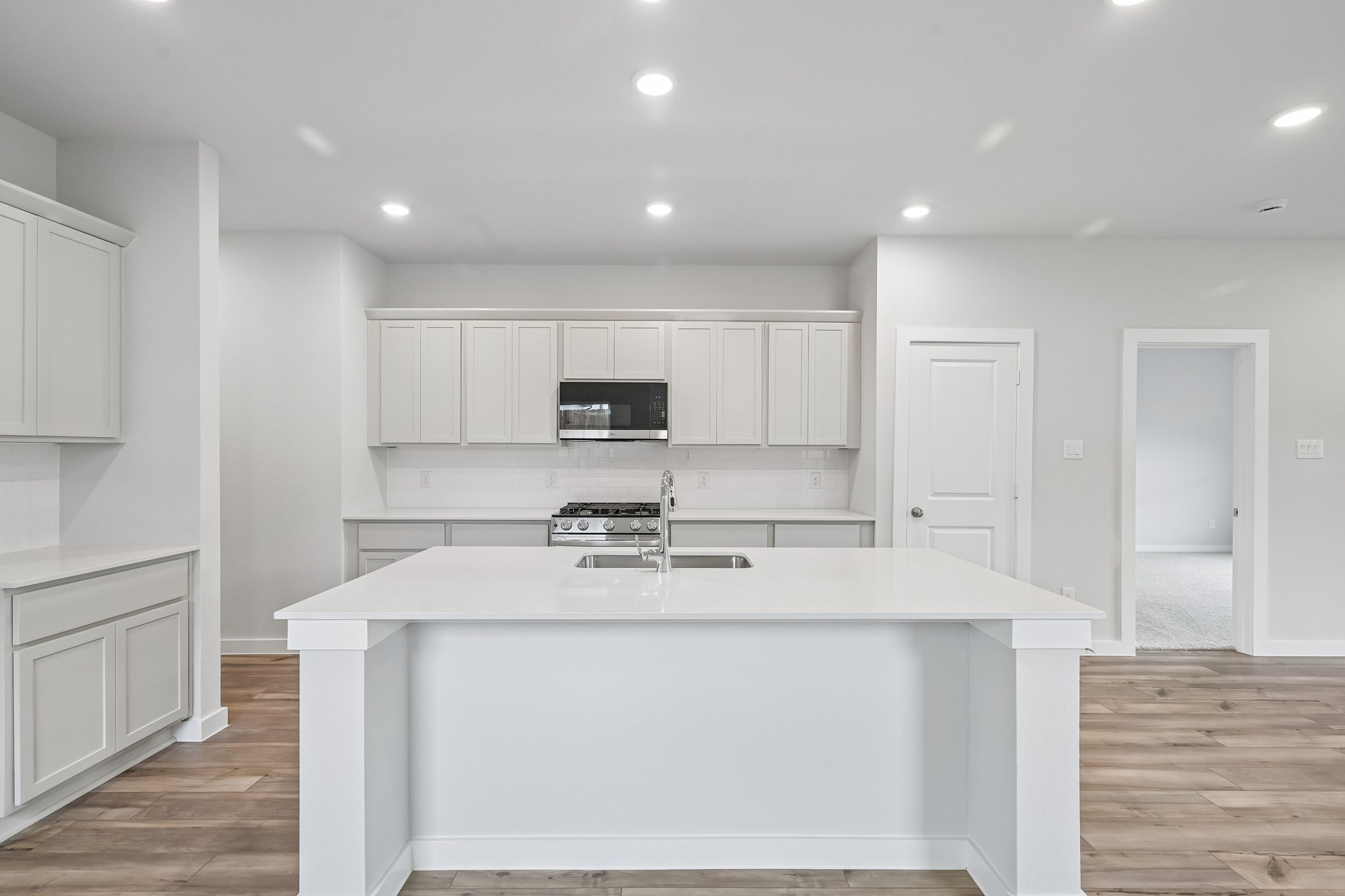 A kitchen with white cabinets.