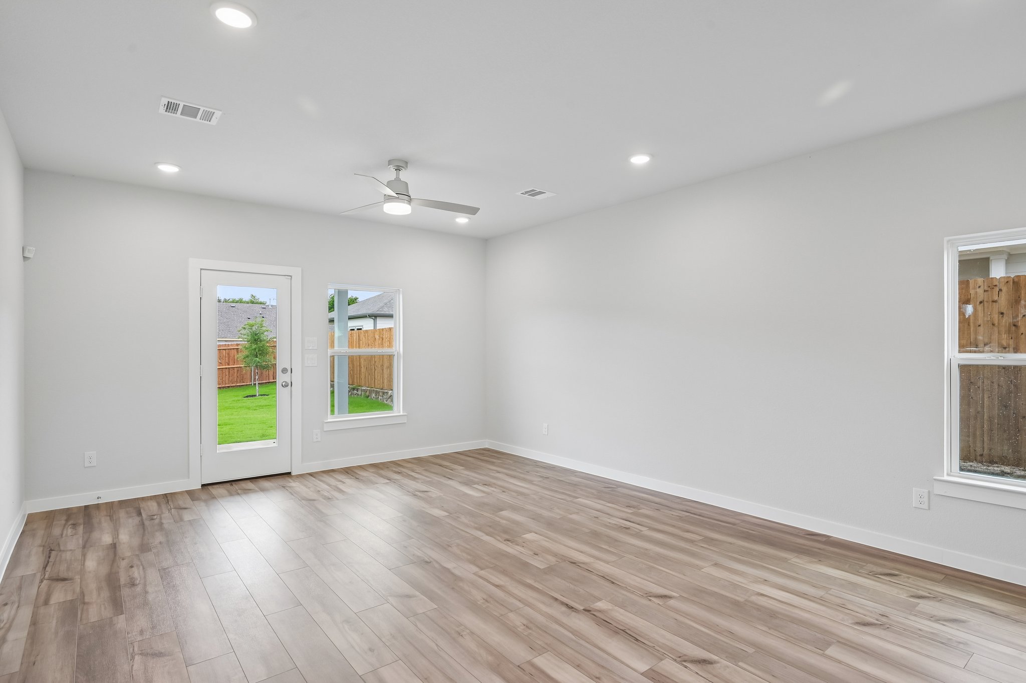 A room with a wood floor and windows.