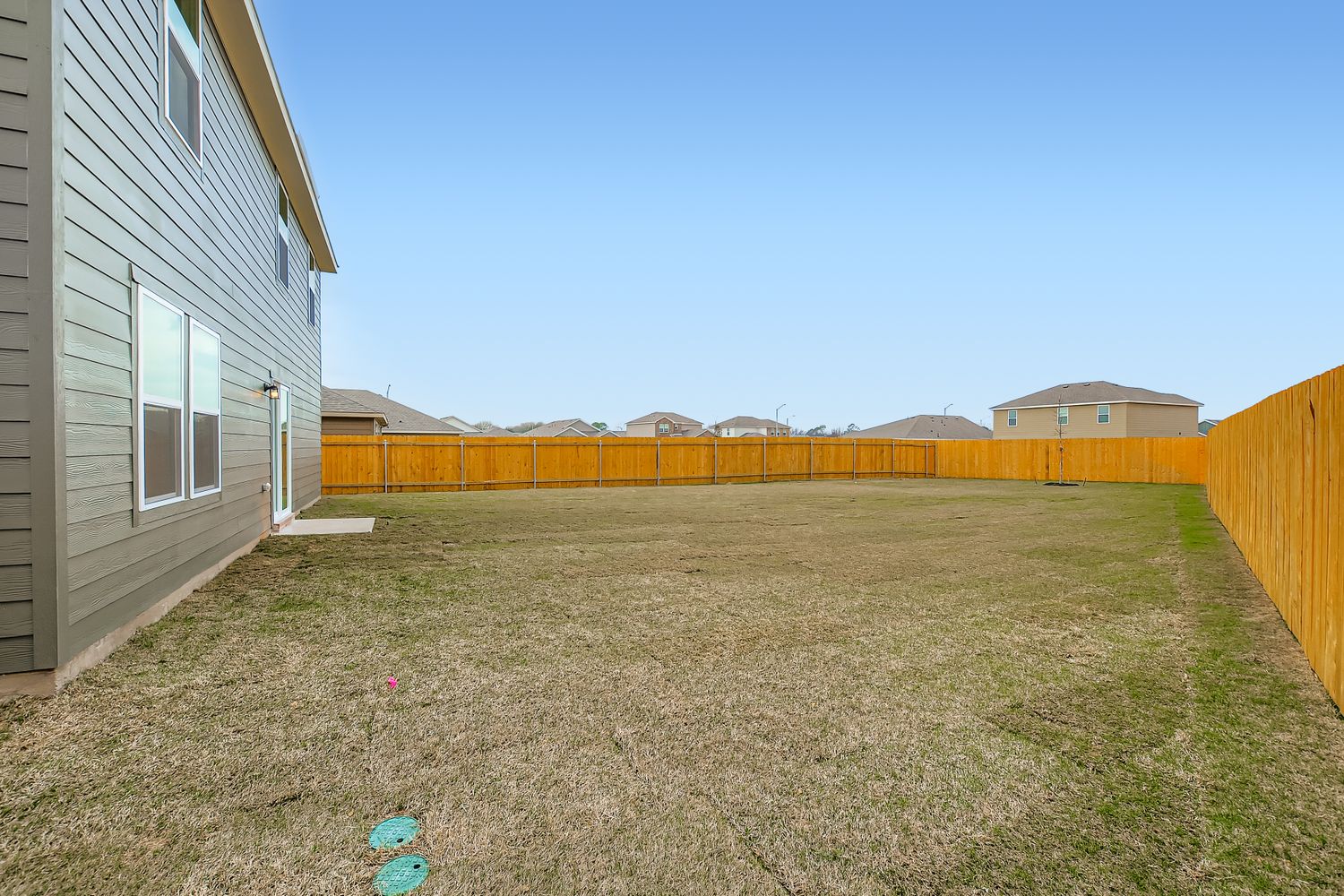 A fenced in yard with a building in the background.