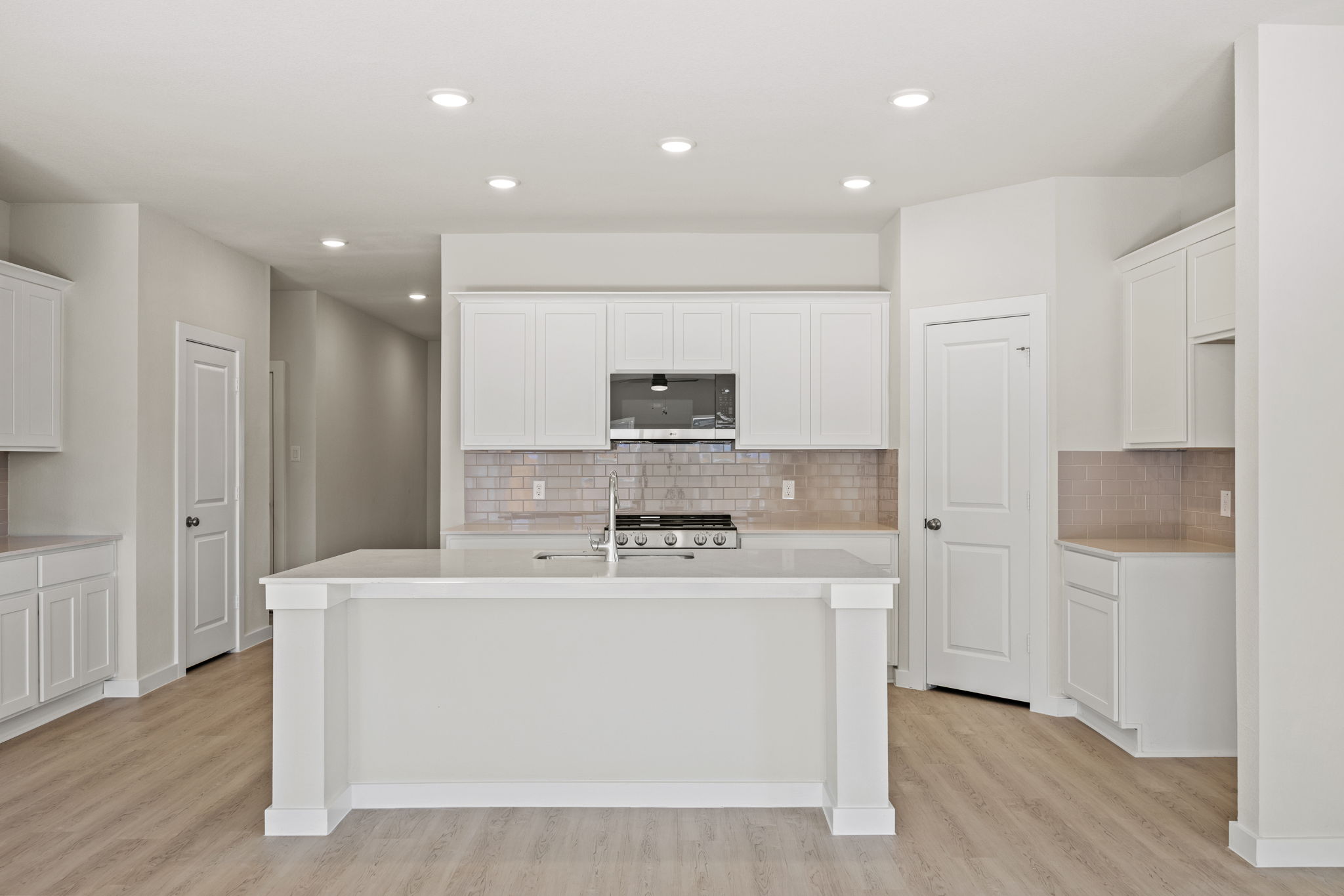 A kitchen with white cabinets.