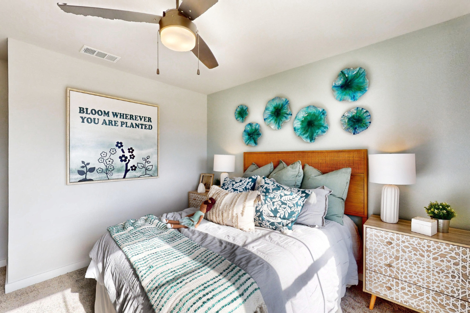 A bedroom with a bed and a fan.