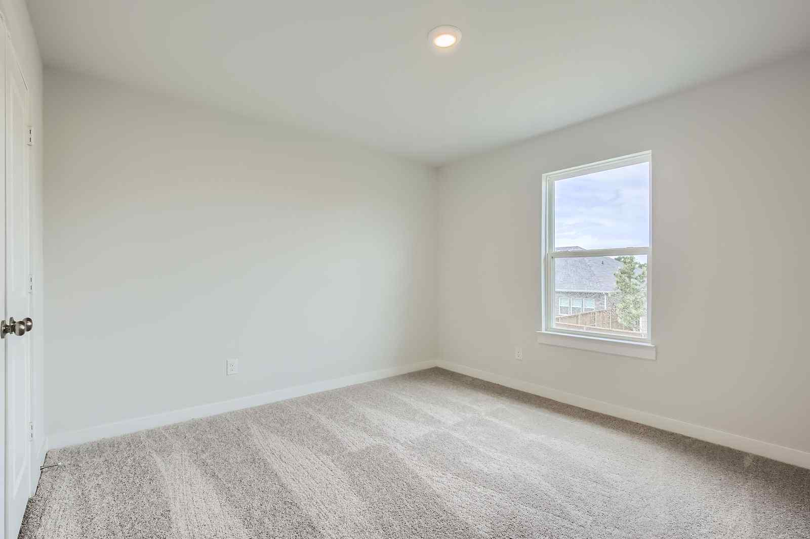 A room with a window and carpet.
