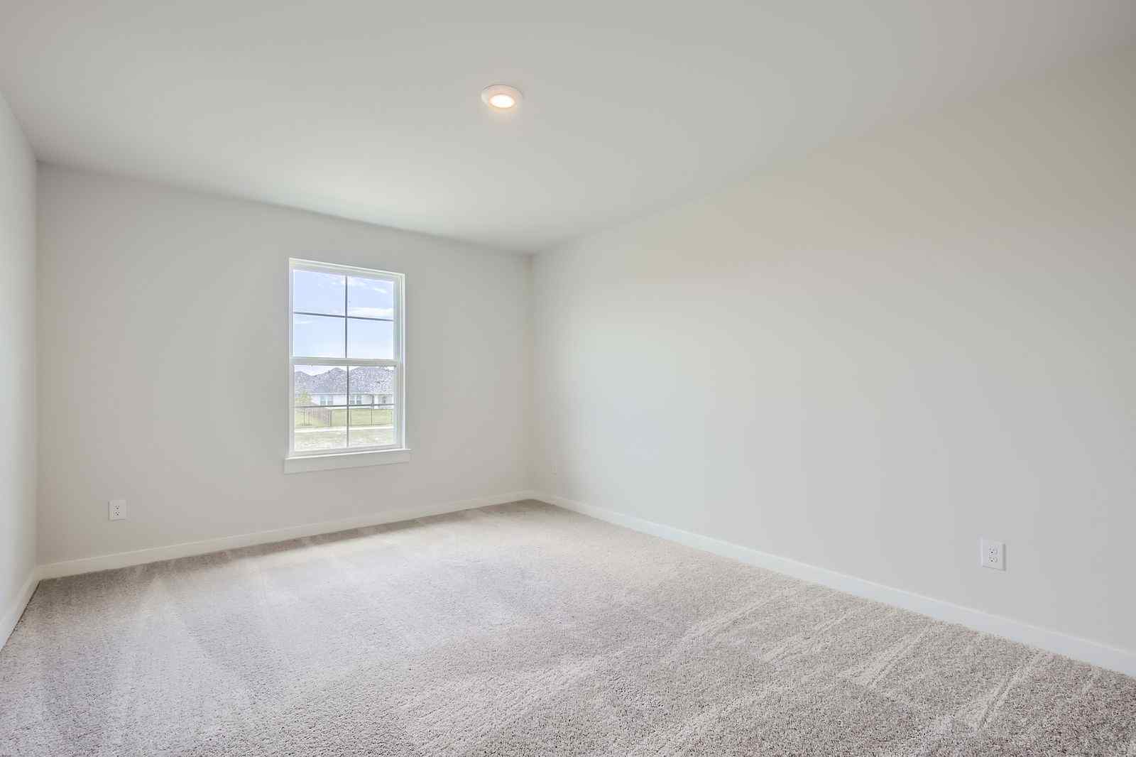 A room with a window and carpet.