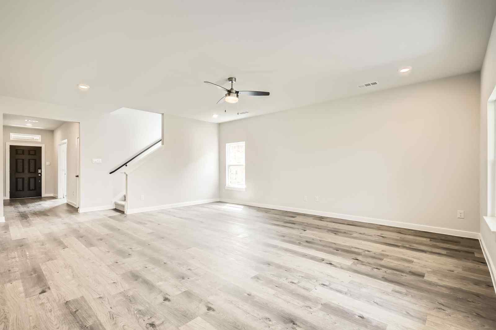 A room with a wood floor and a ceiling fan.
