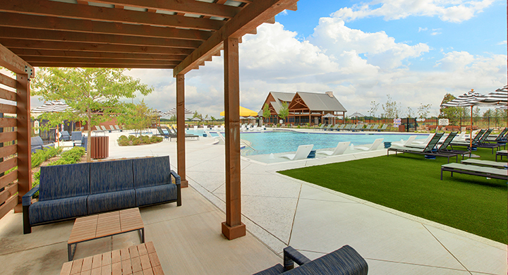 A pool with lounge chairs and a lounge chair on a deck.