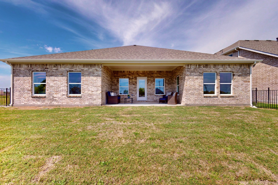 A brick house with a grass yard.