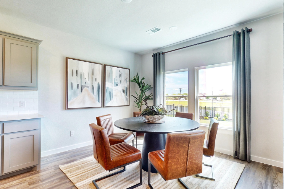 A dining room with a table and chairs.