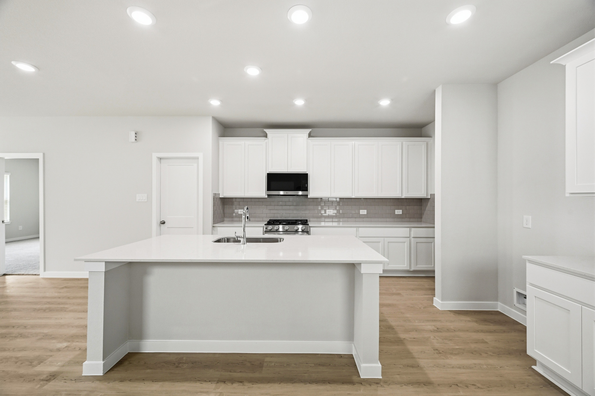 A kitchen with white cabinets.