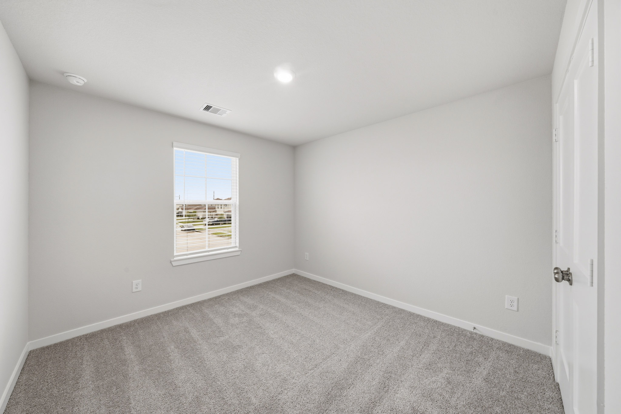 A room with a carpet and a window.