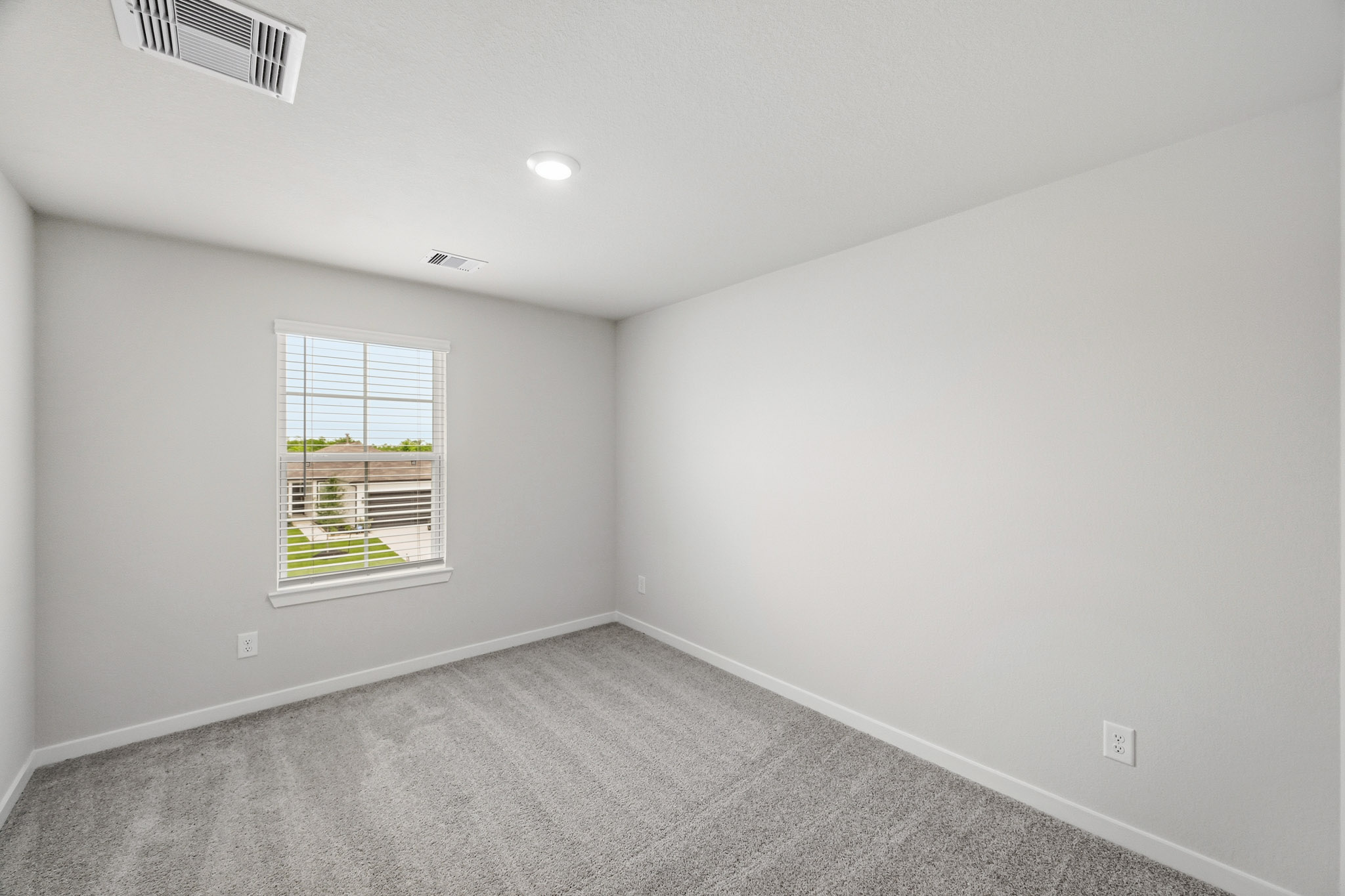 A room with a window and a carpet.
