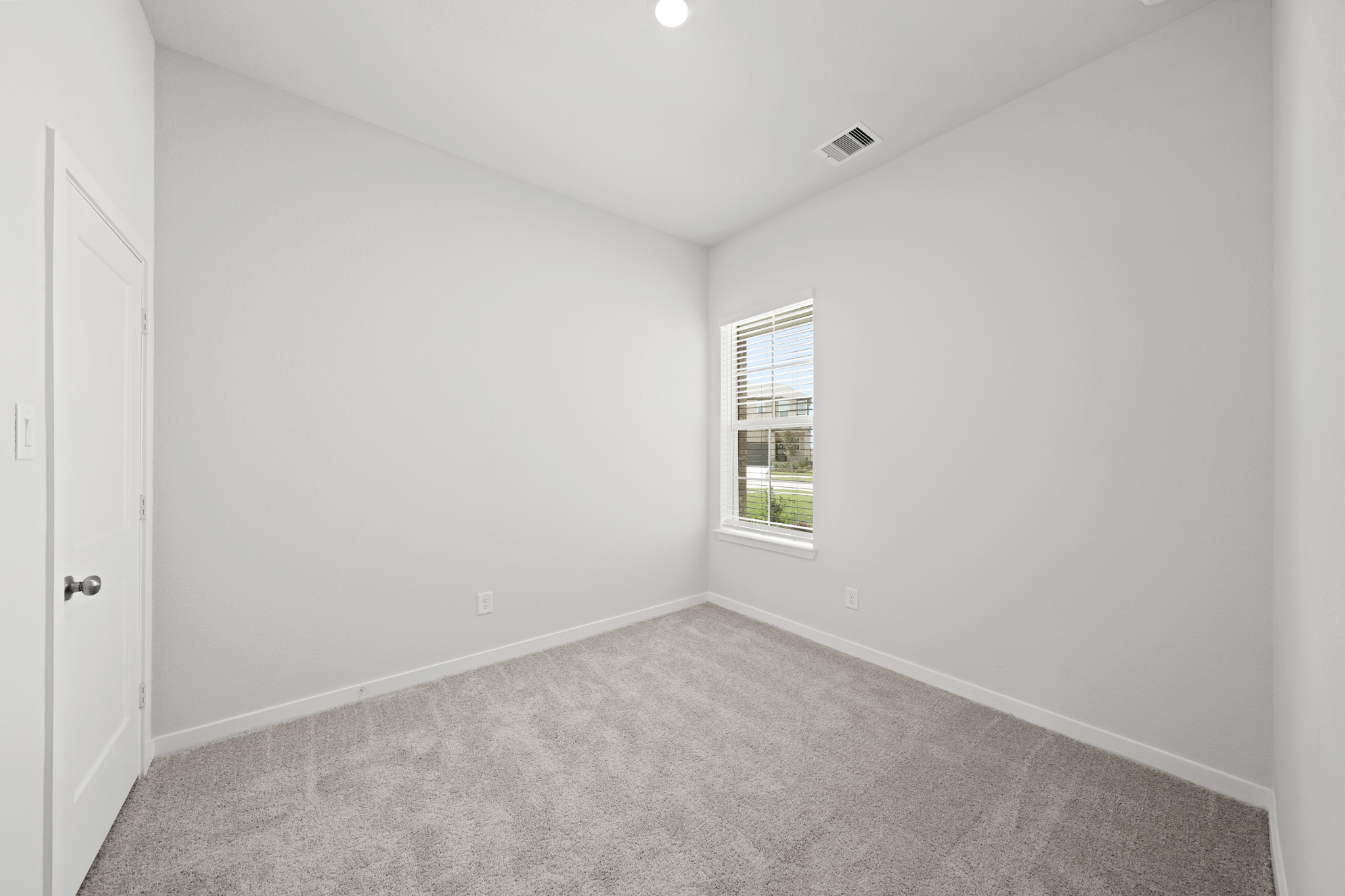 A room with a carpet and a window.