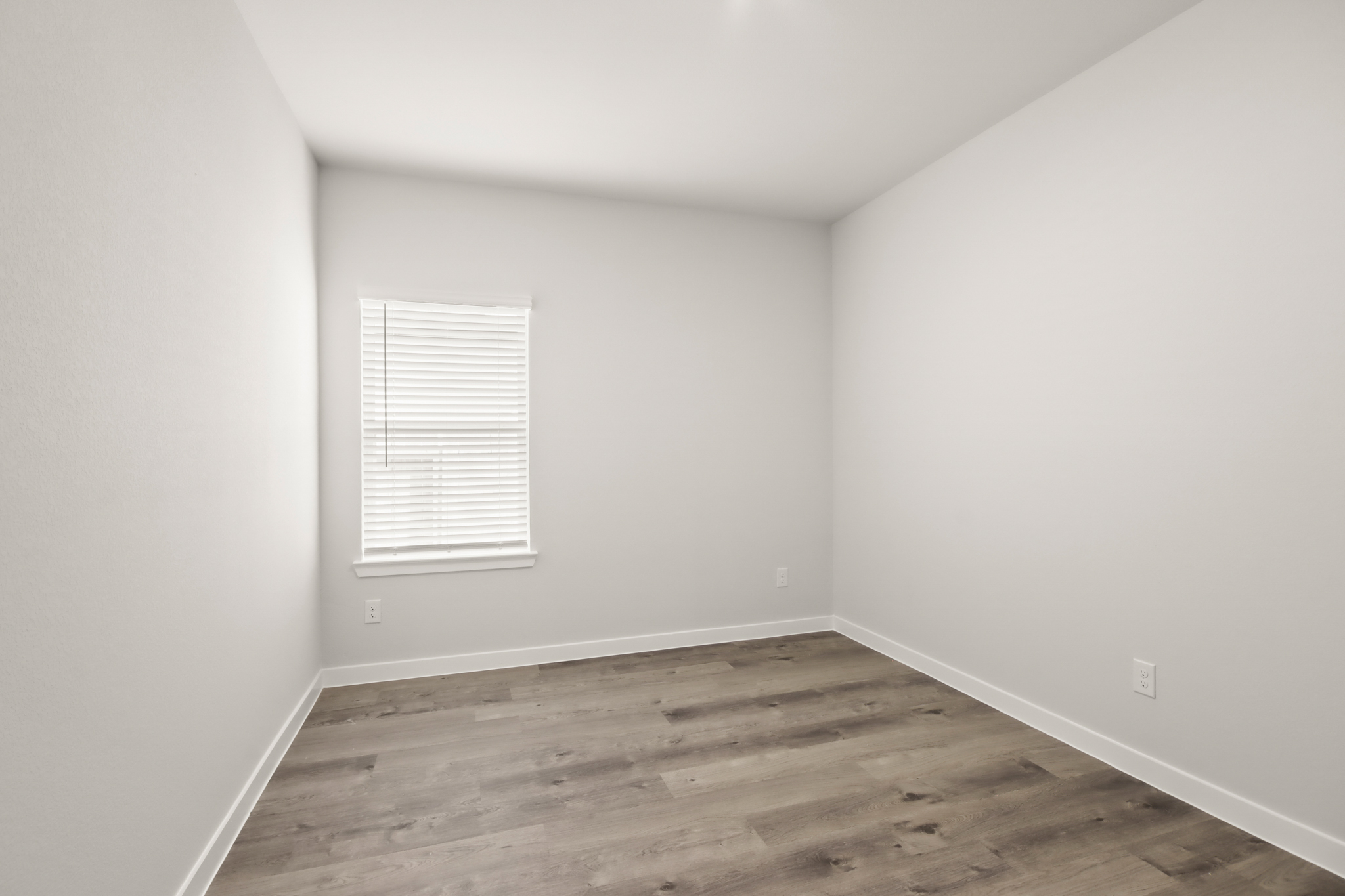A room with a wood floor and a window.