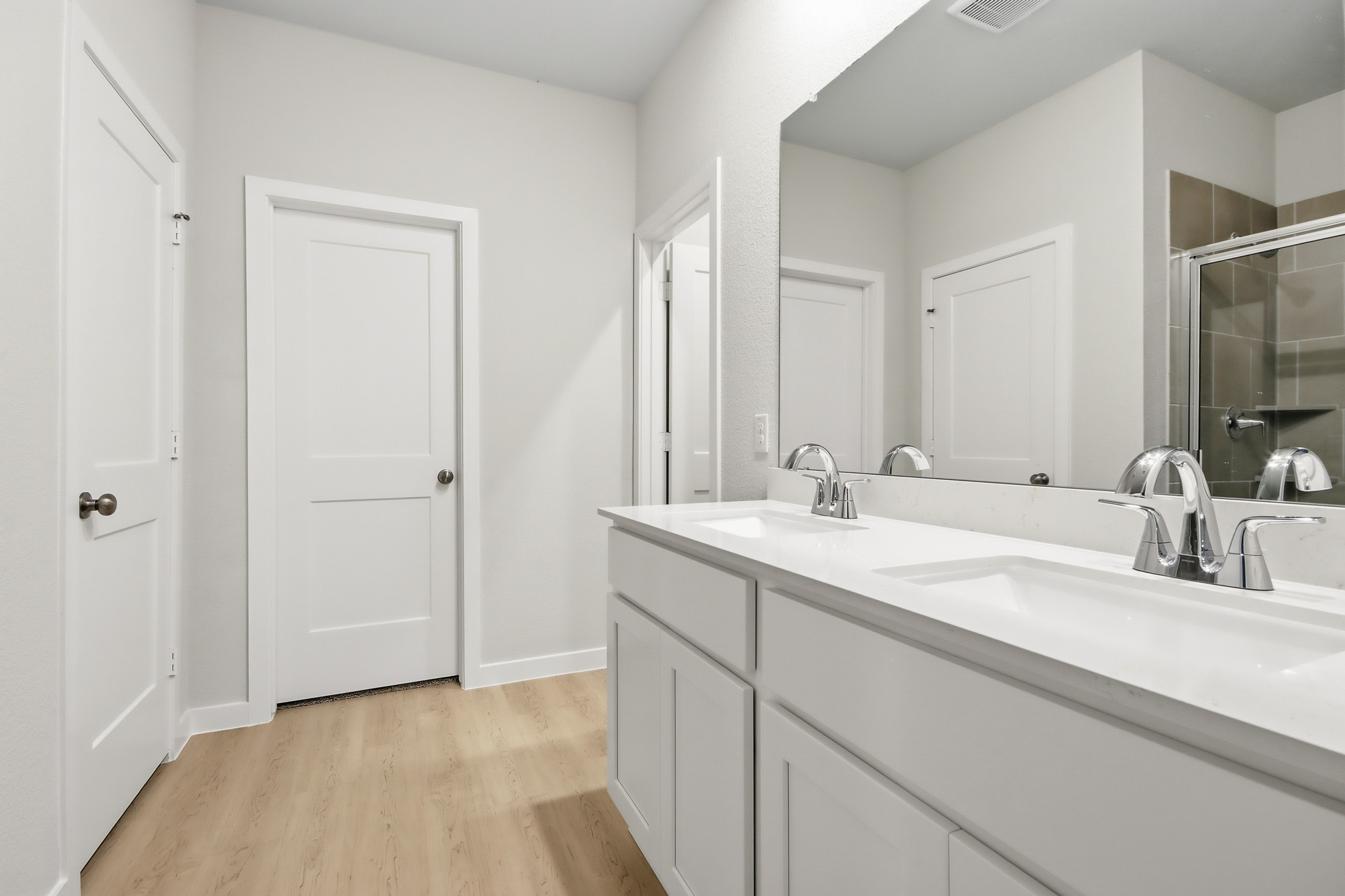A bathroom with white cabinets.