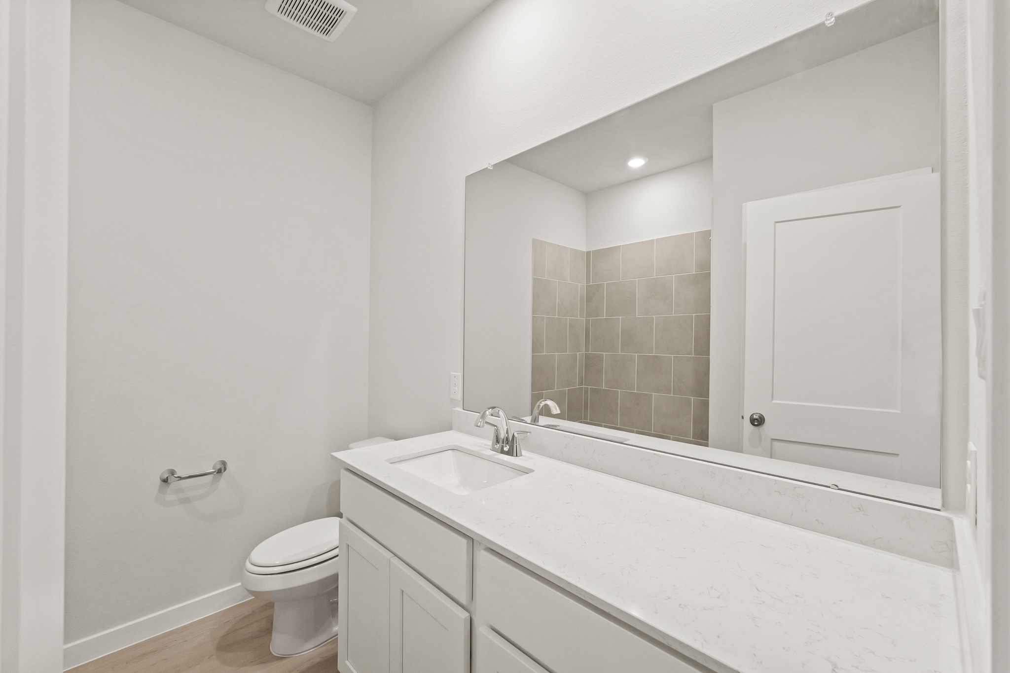 A bathroom with a large mirror.