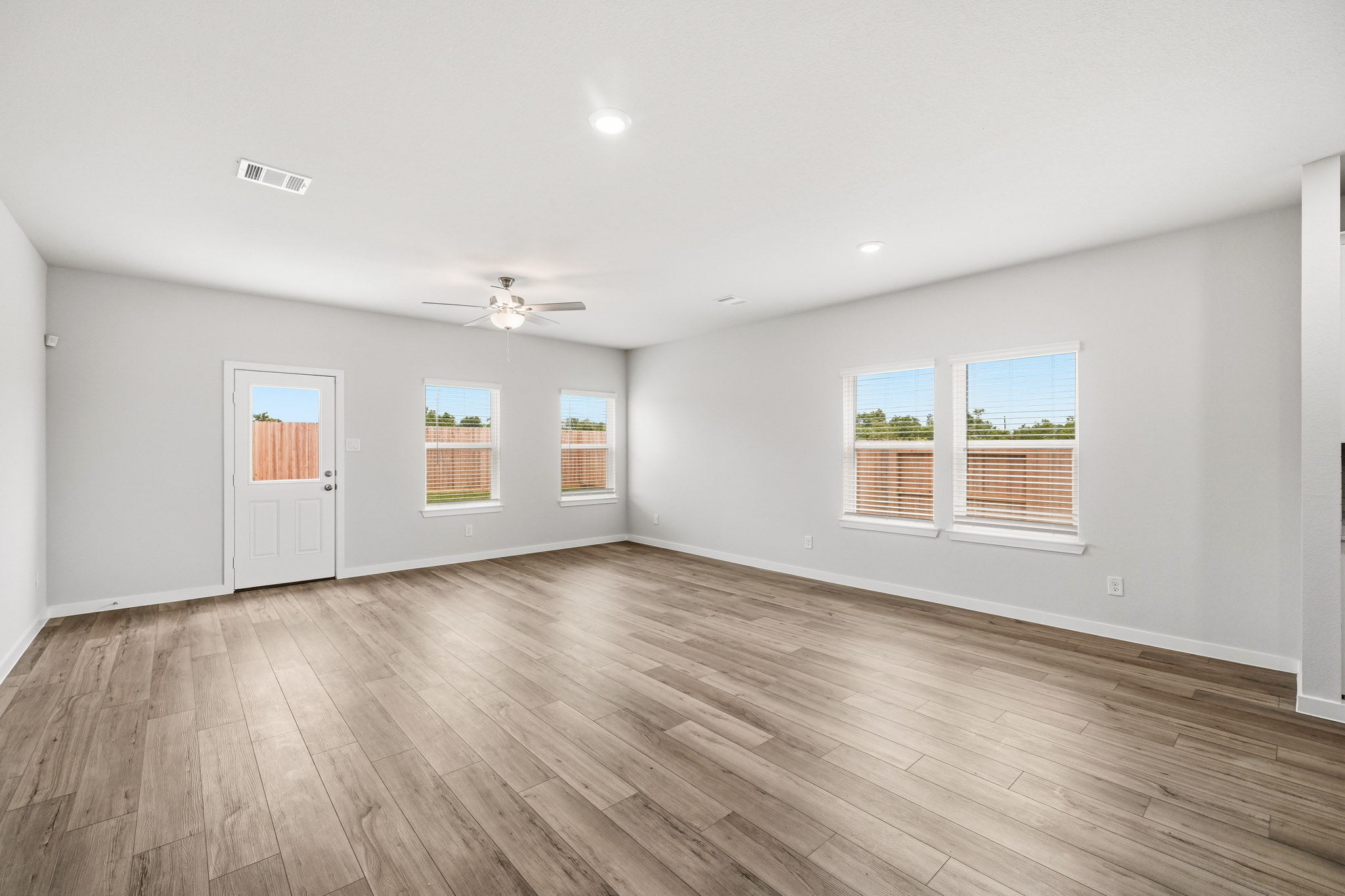 A room with a wood floor and a wood floor with a ceiling fan.