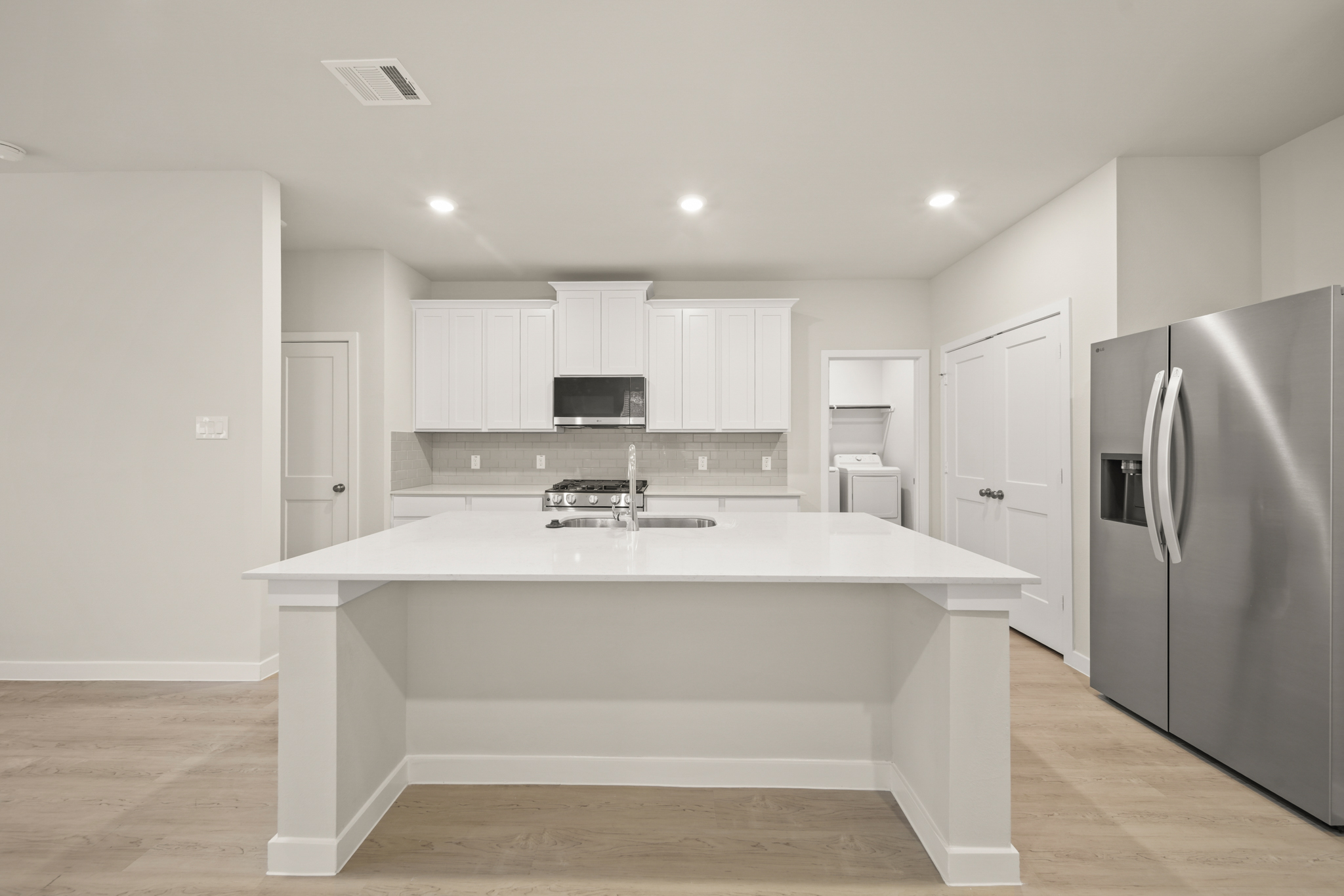 A kitchen with white cabinets.