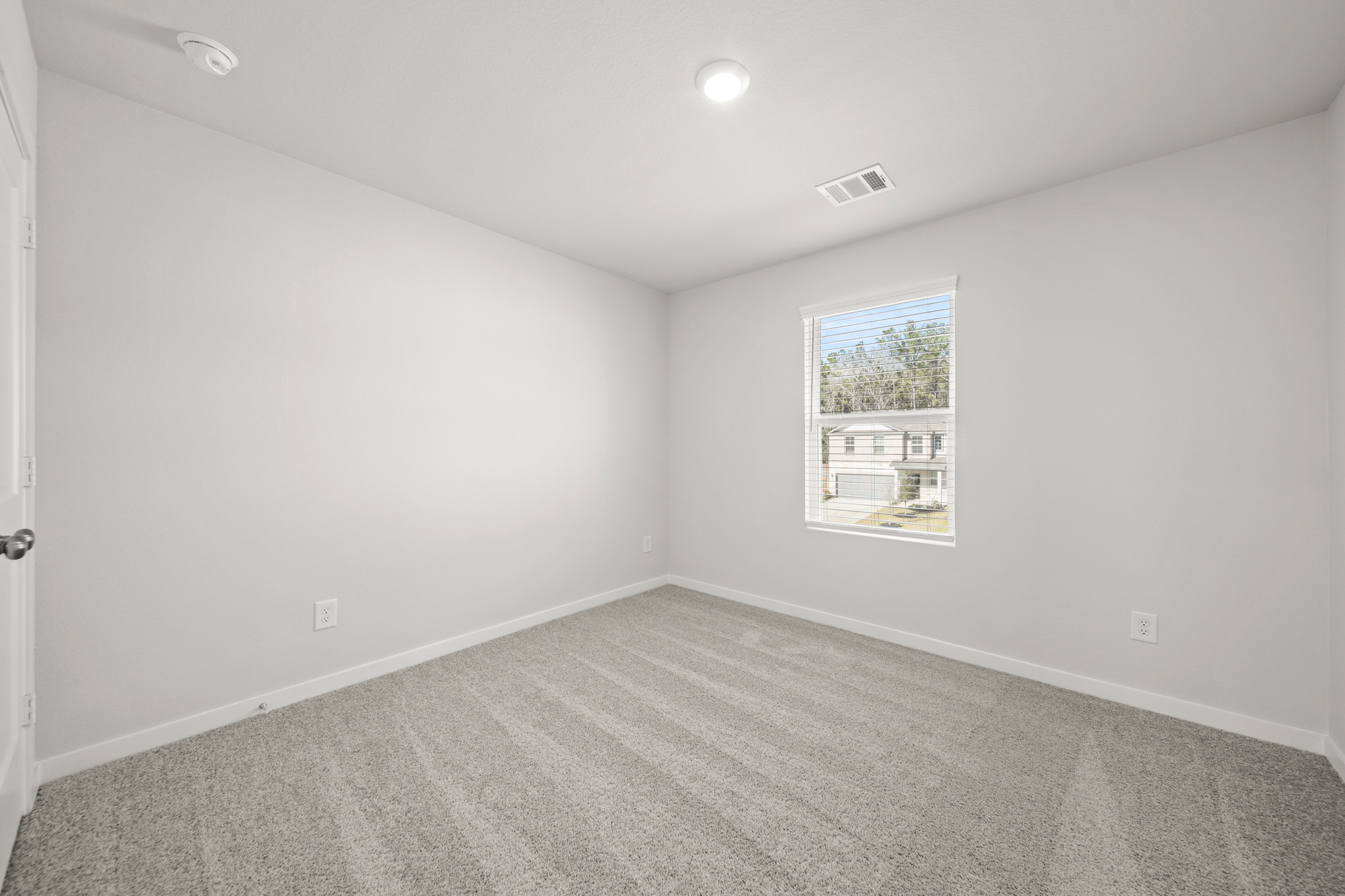 A room with a window and a carpet.