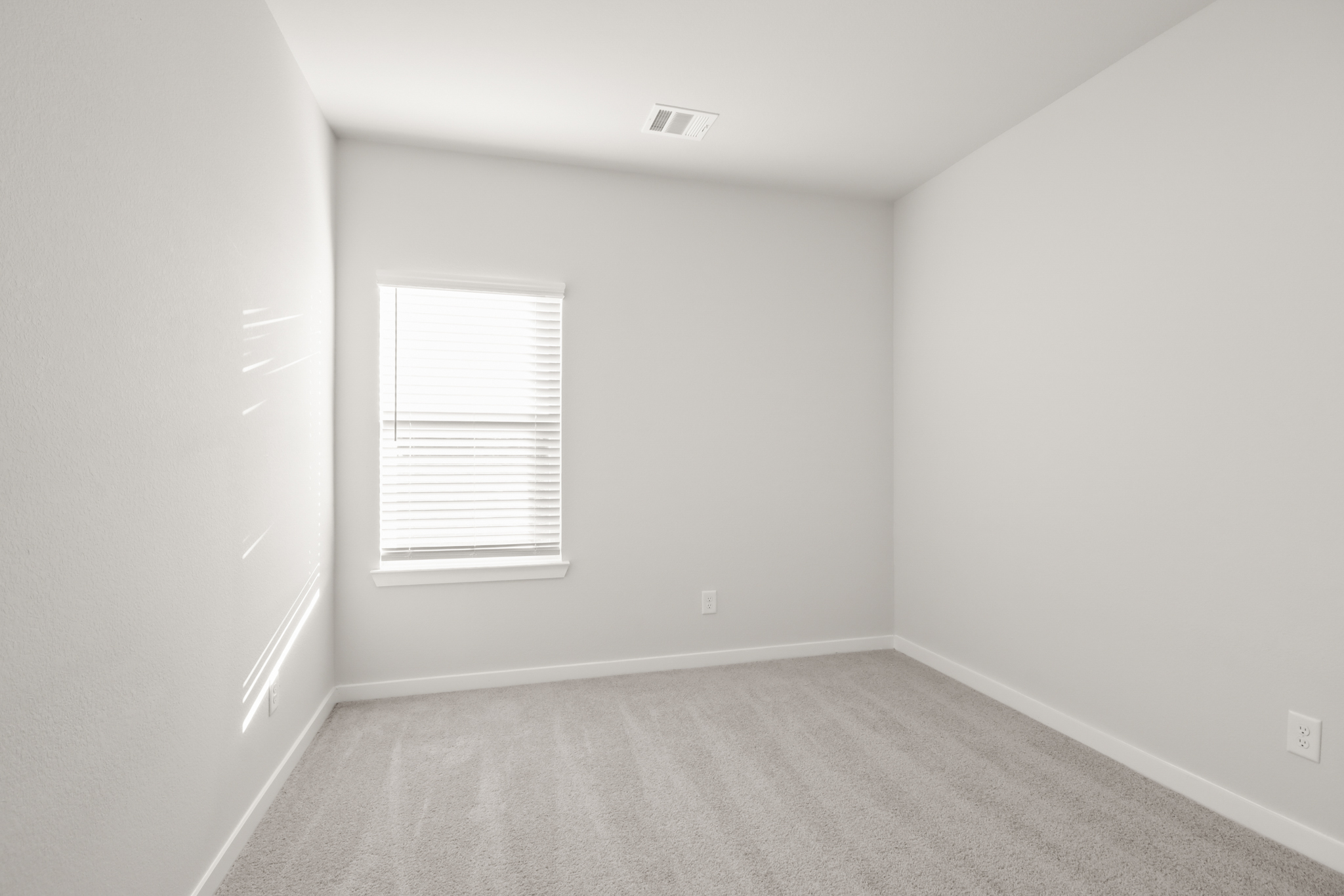 A room with a window and a carpet.