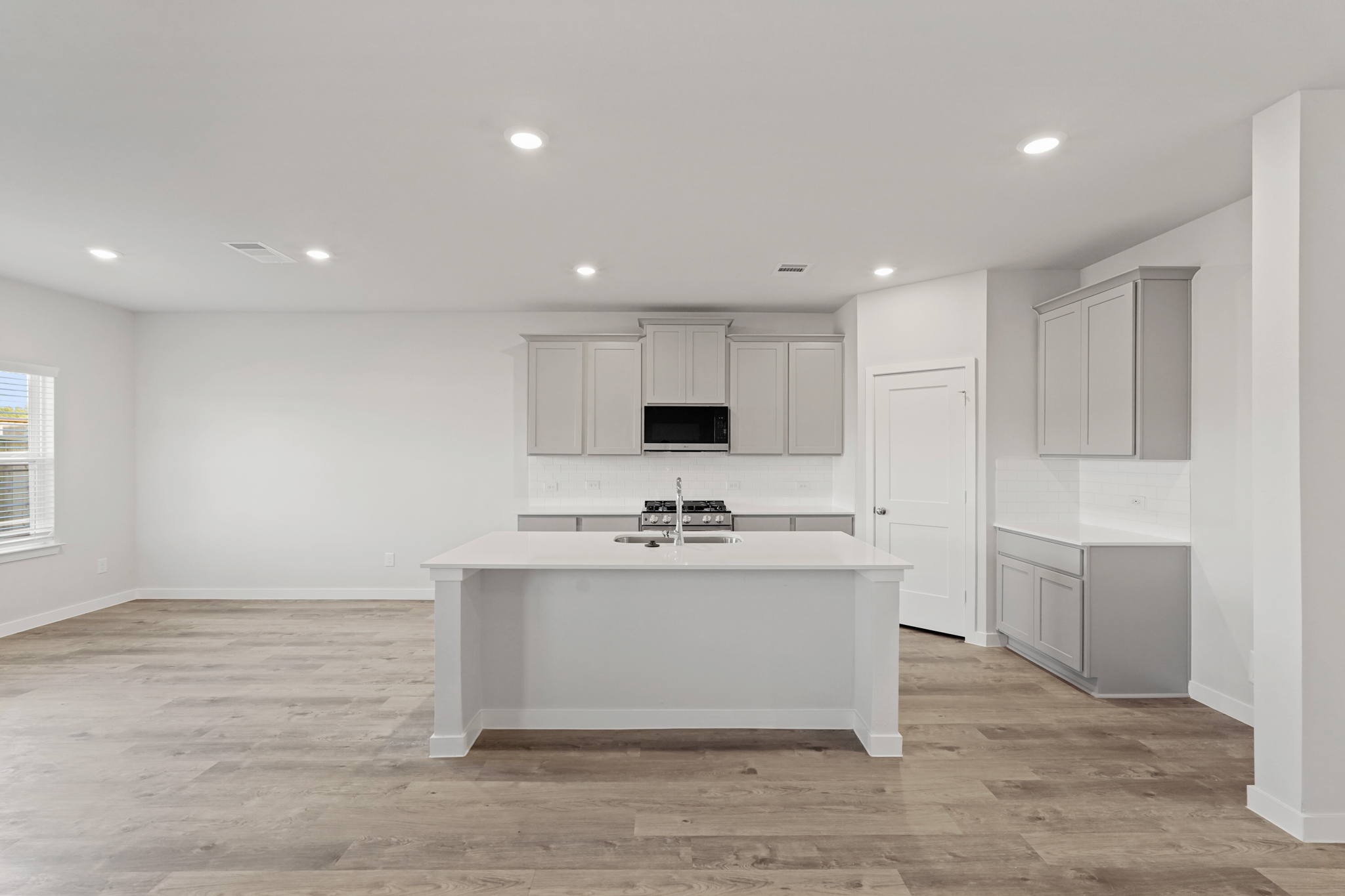 A kitchen with white cabinets.