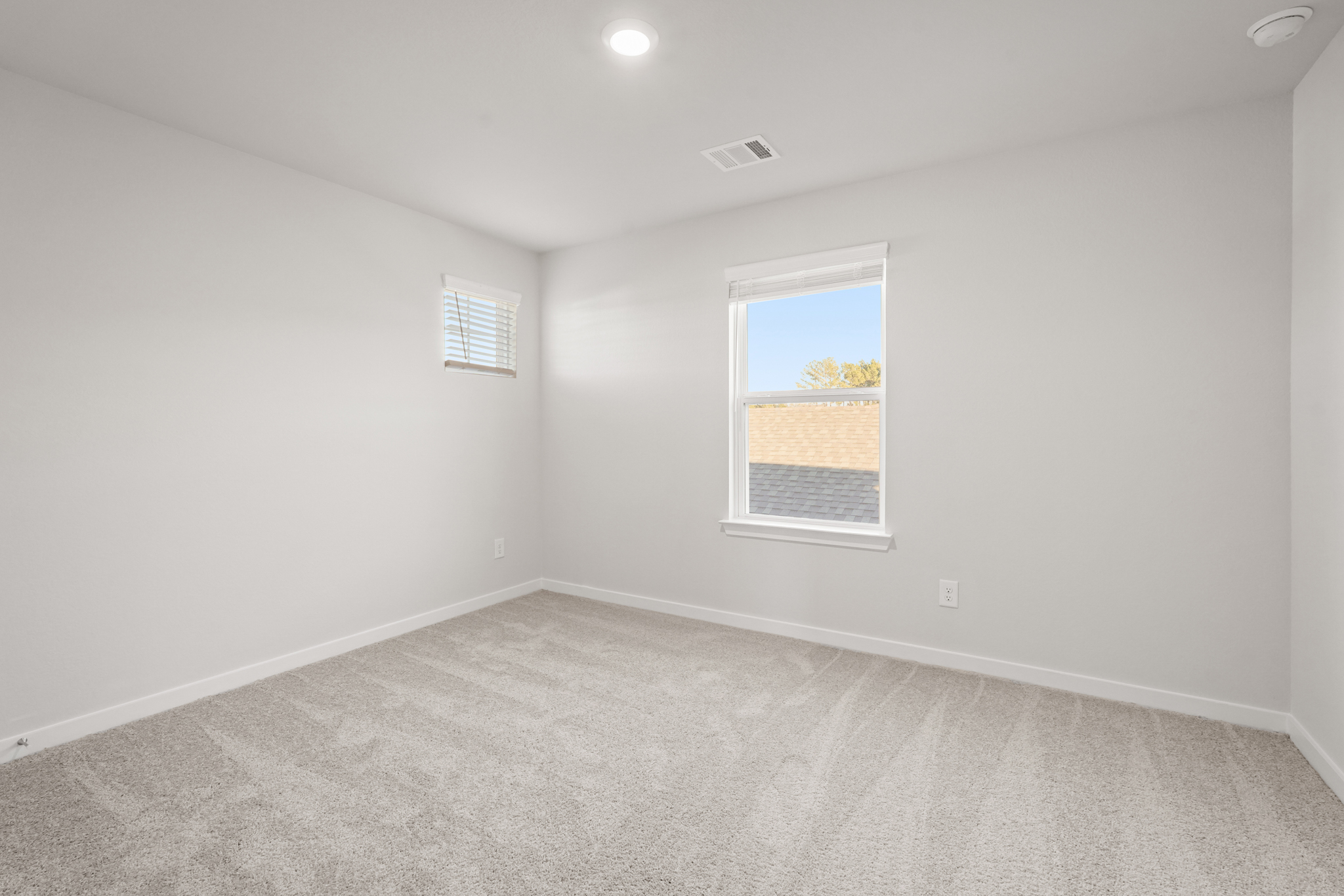 A room with a window and a carpet.