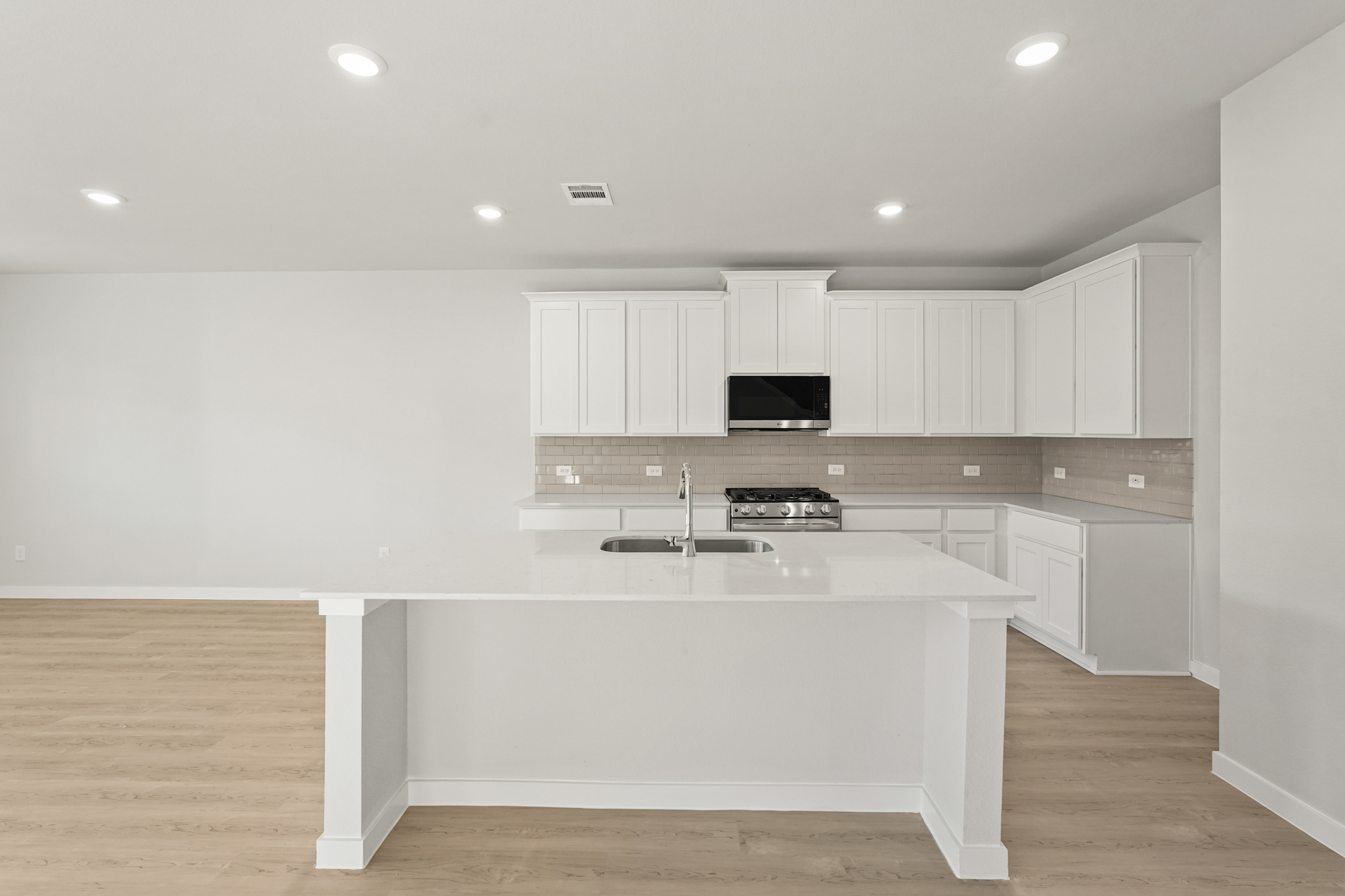 A kitchen with white cabinets.