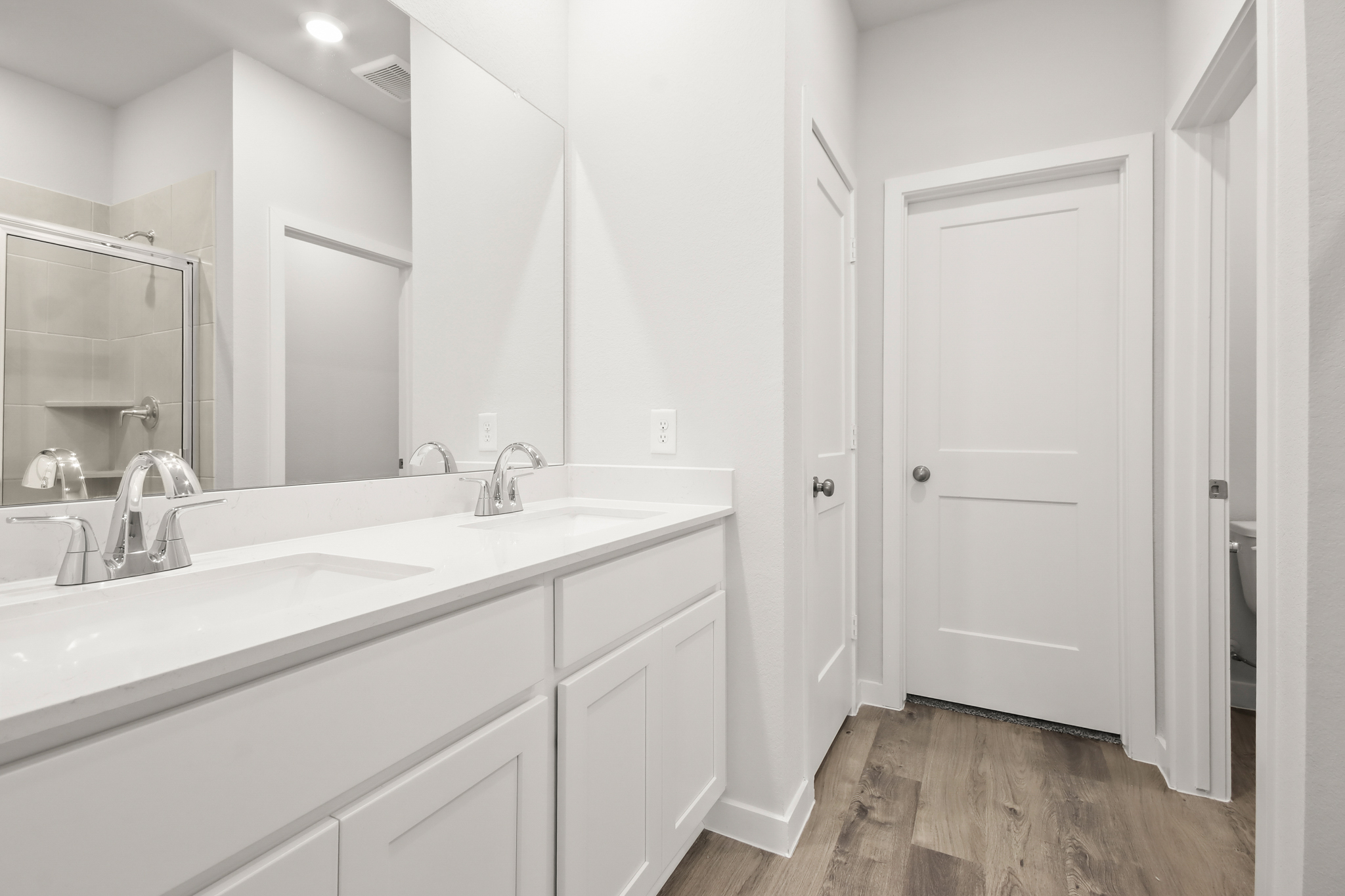 A bathroom with white cabinets.