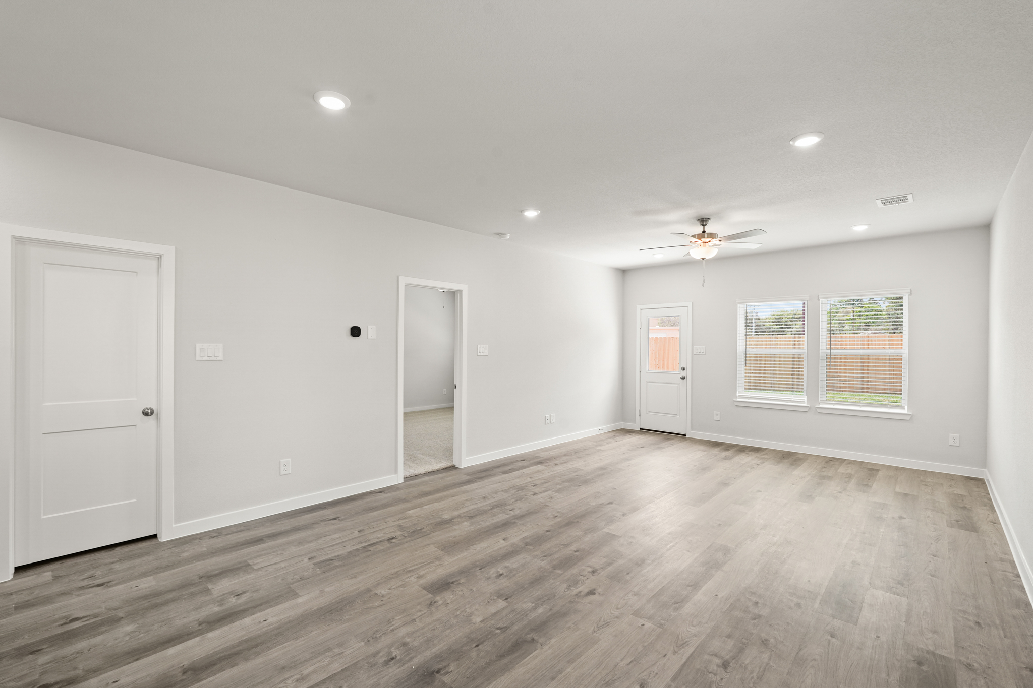 A room with a wood floor and white walls.