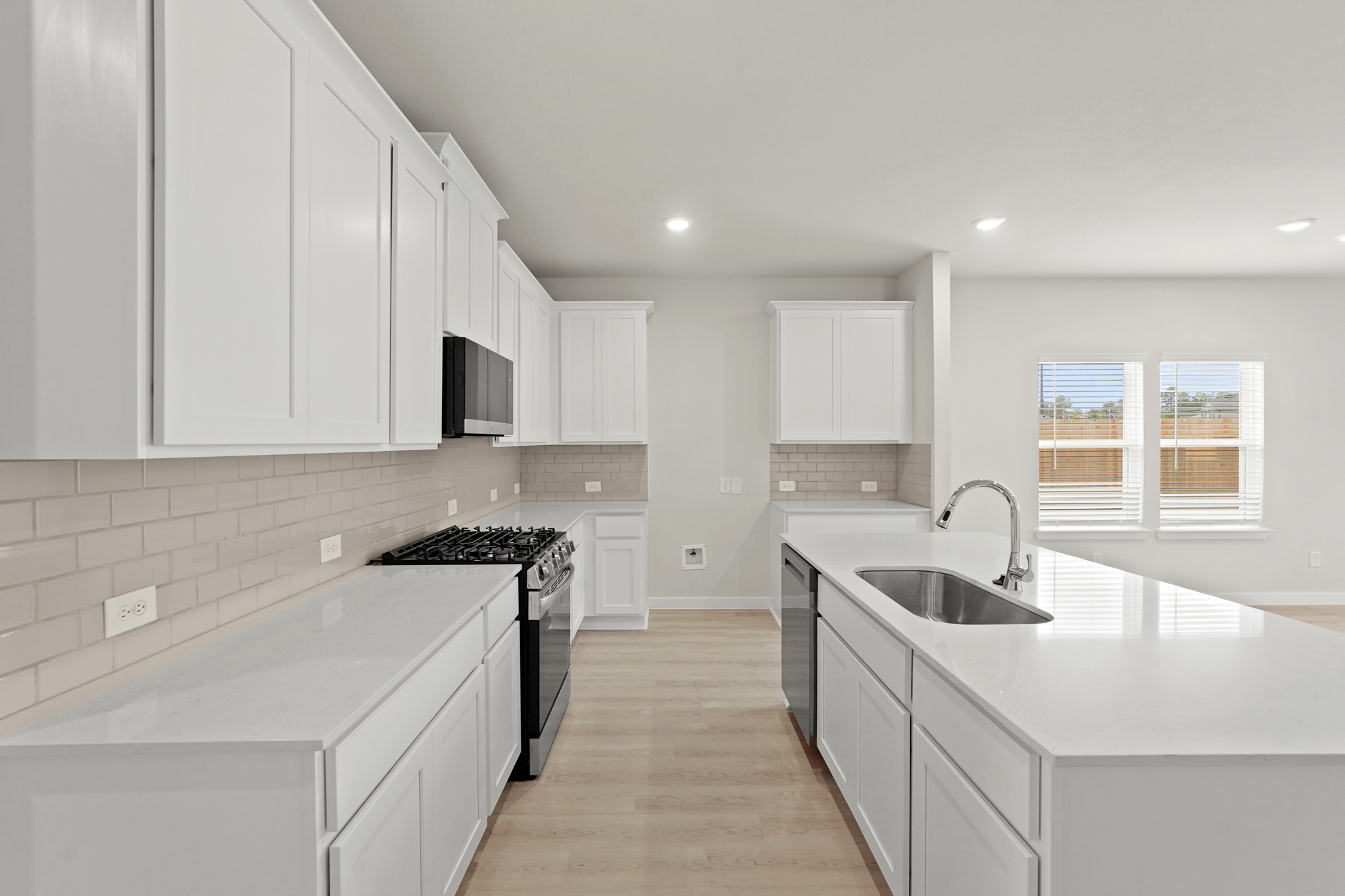 A kitchen with white cabinets.