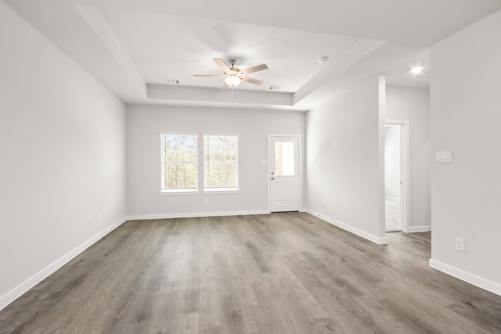 A room with a wood floor and a ceiling fan.