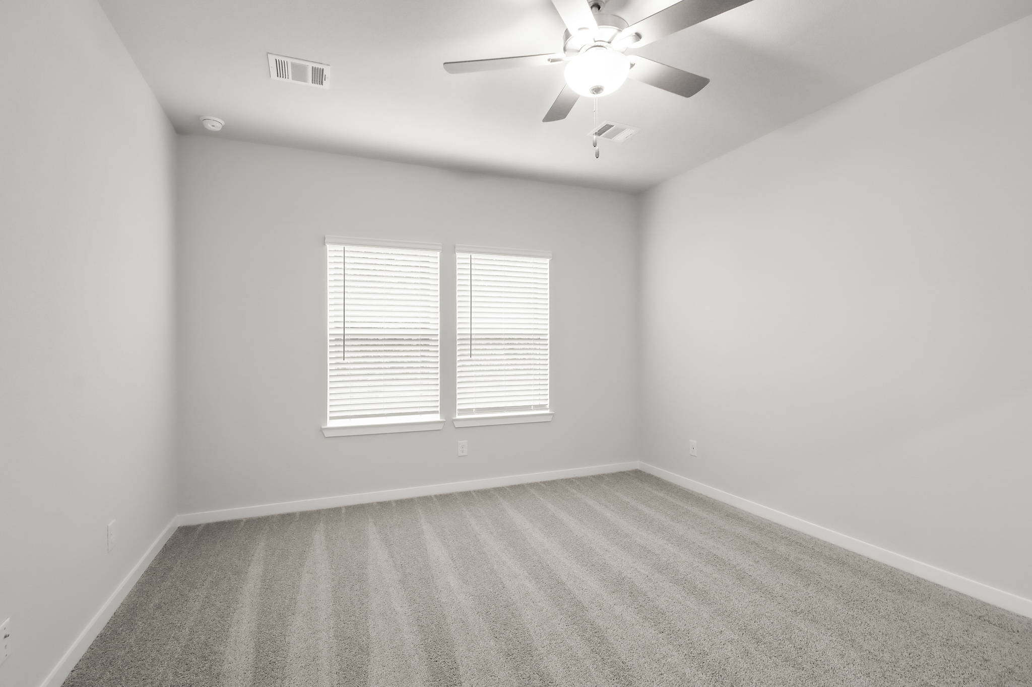 A room with a ceiling fan and a window.