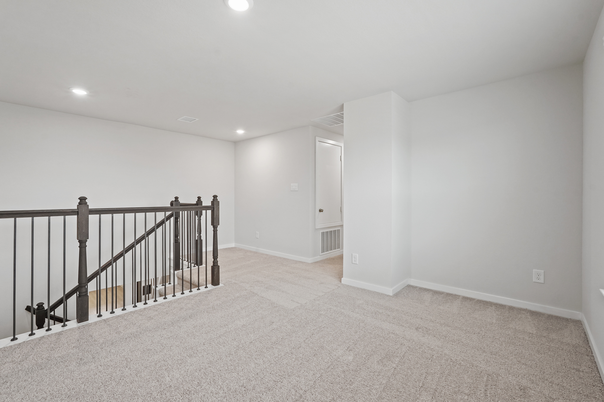 A room with a railing and a door.