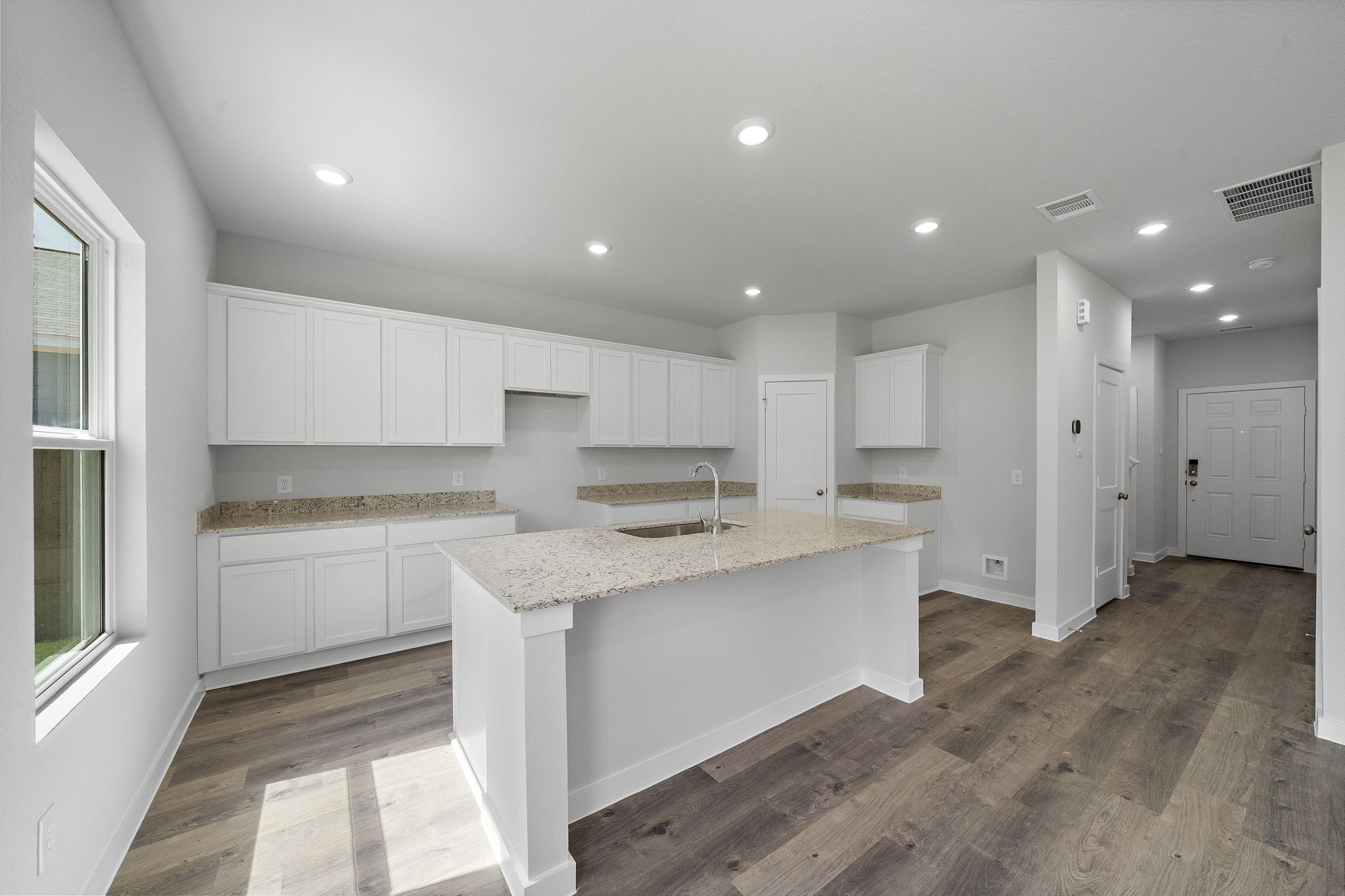 A kitchen with white cabinets.
