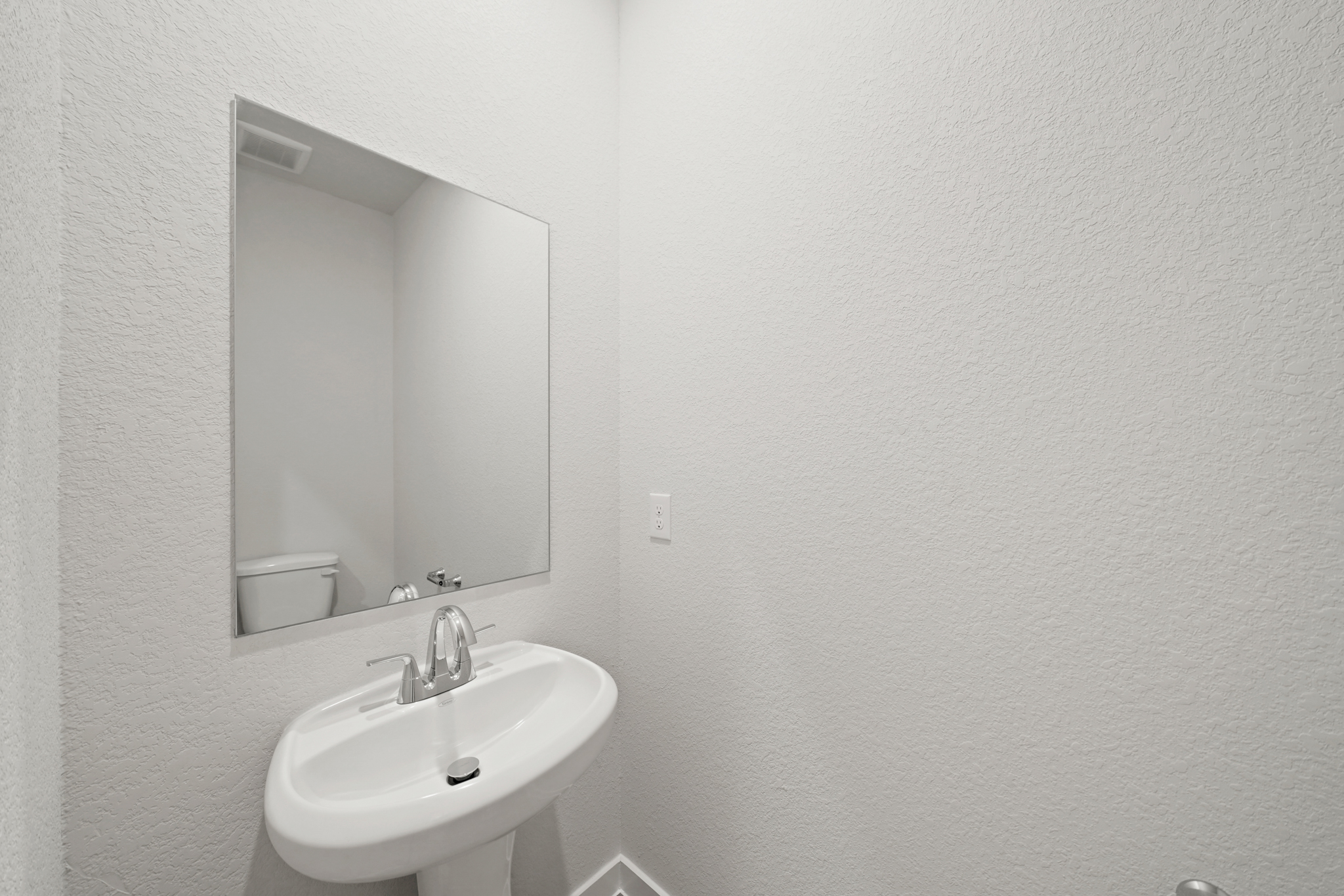 A bathroom with a mirror and sink.