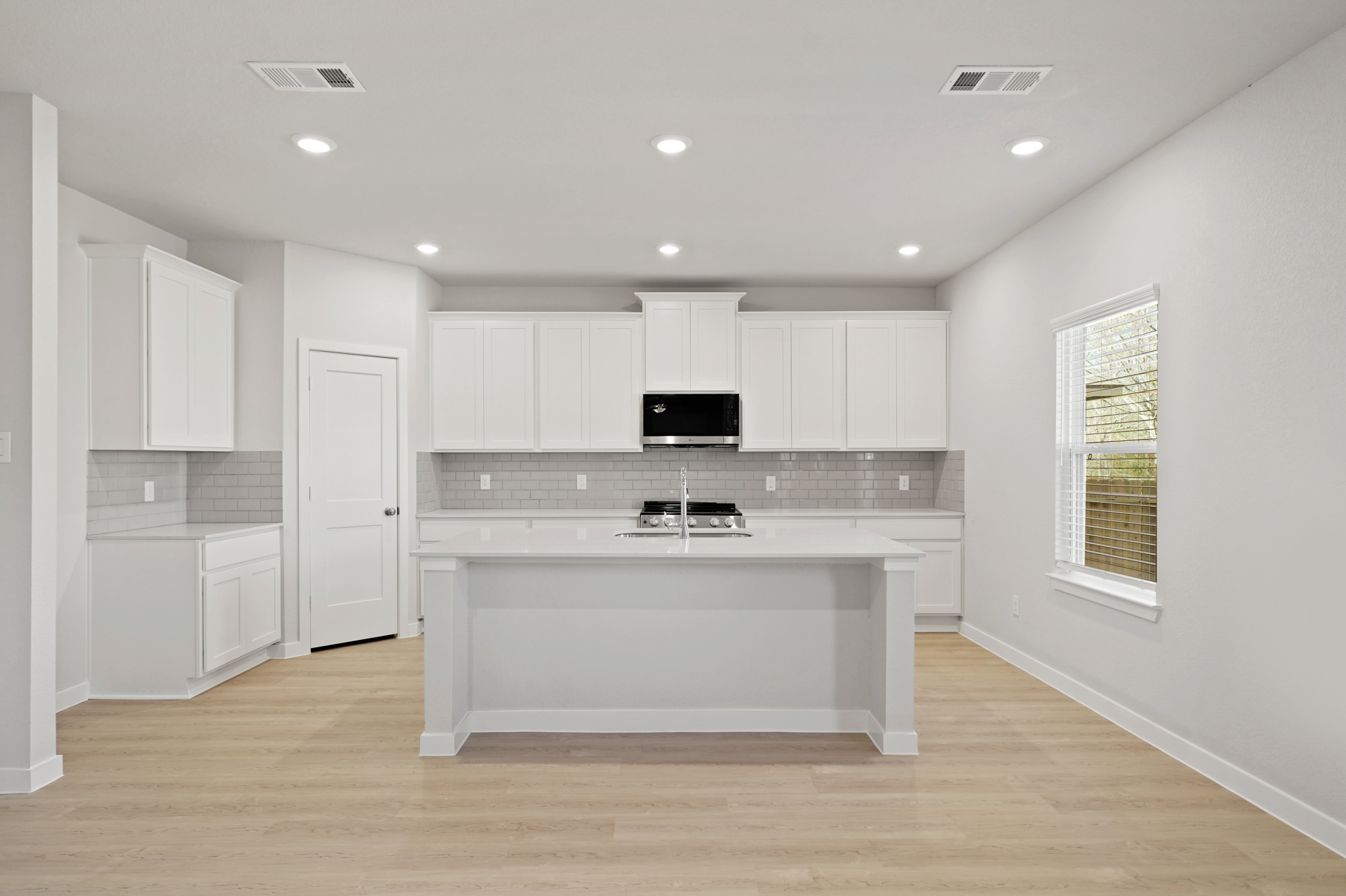 A kitchen with white cabinets.