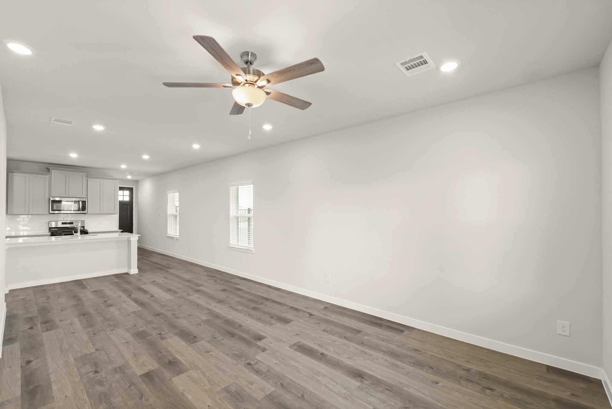 A large kitchen with a ceiling fan.