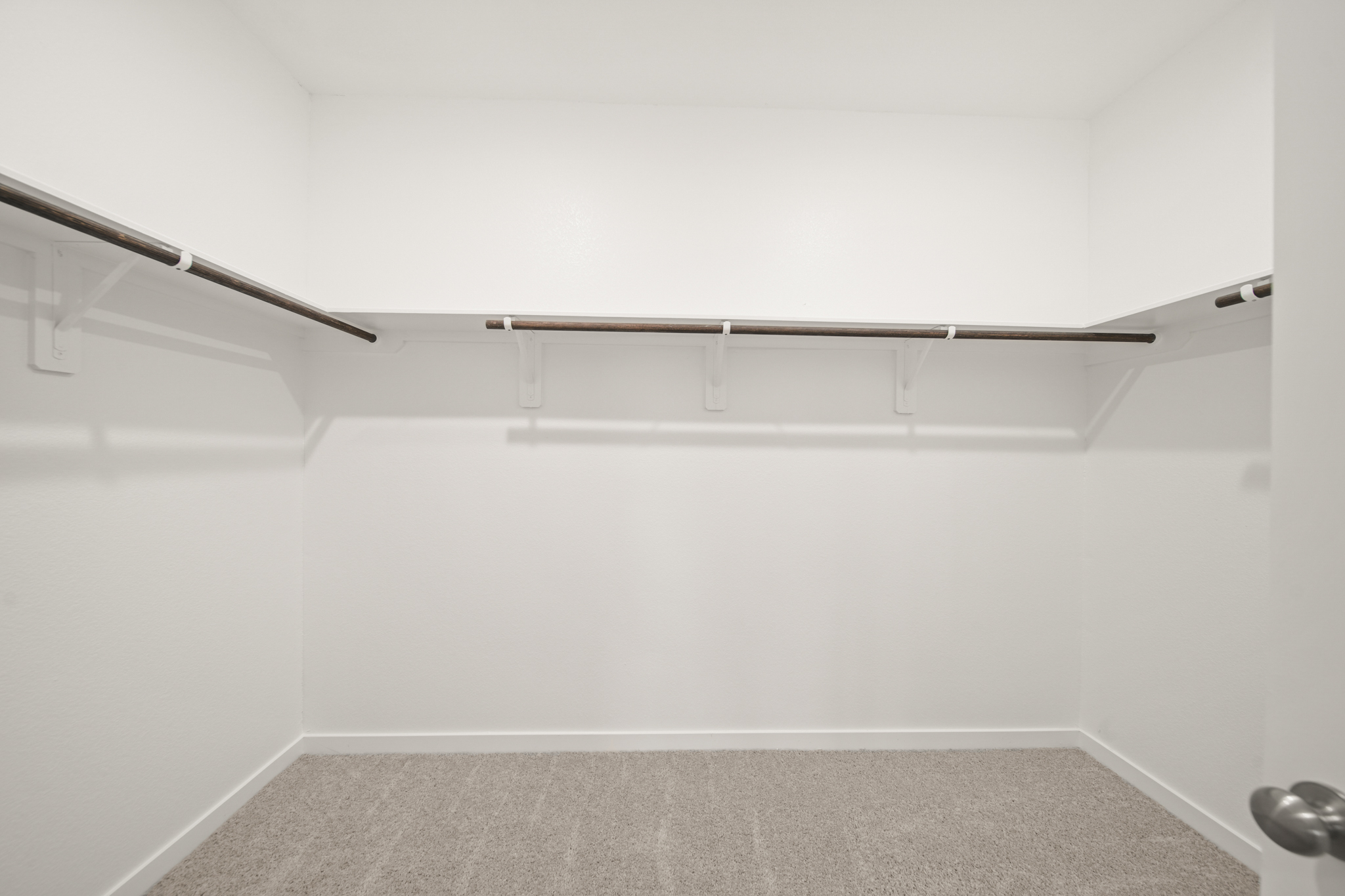 A white wall with a metal bar.