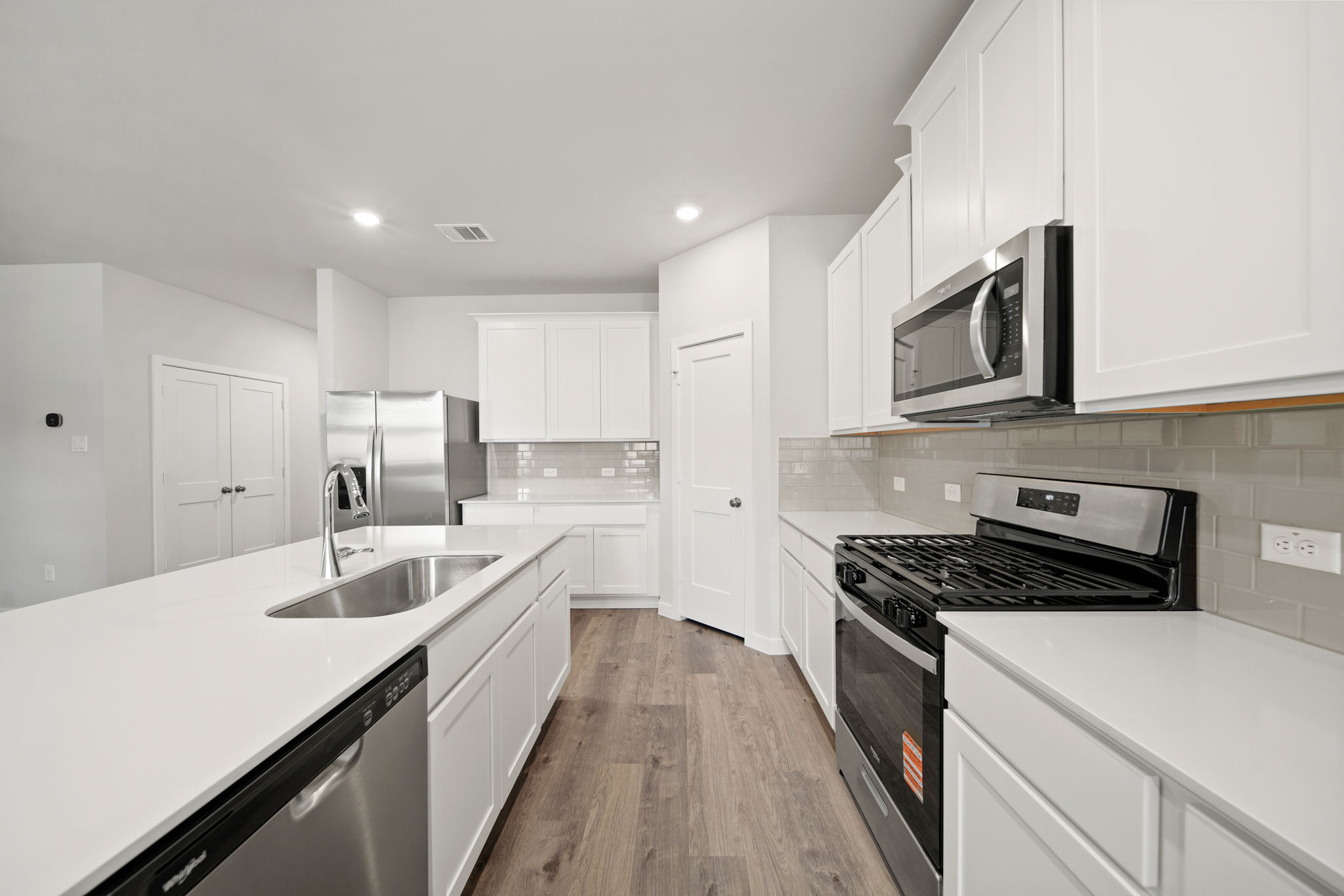 A kitchen with white cabinets.