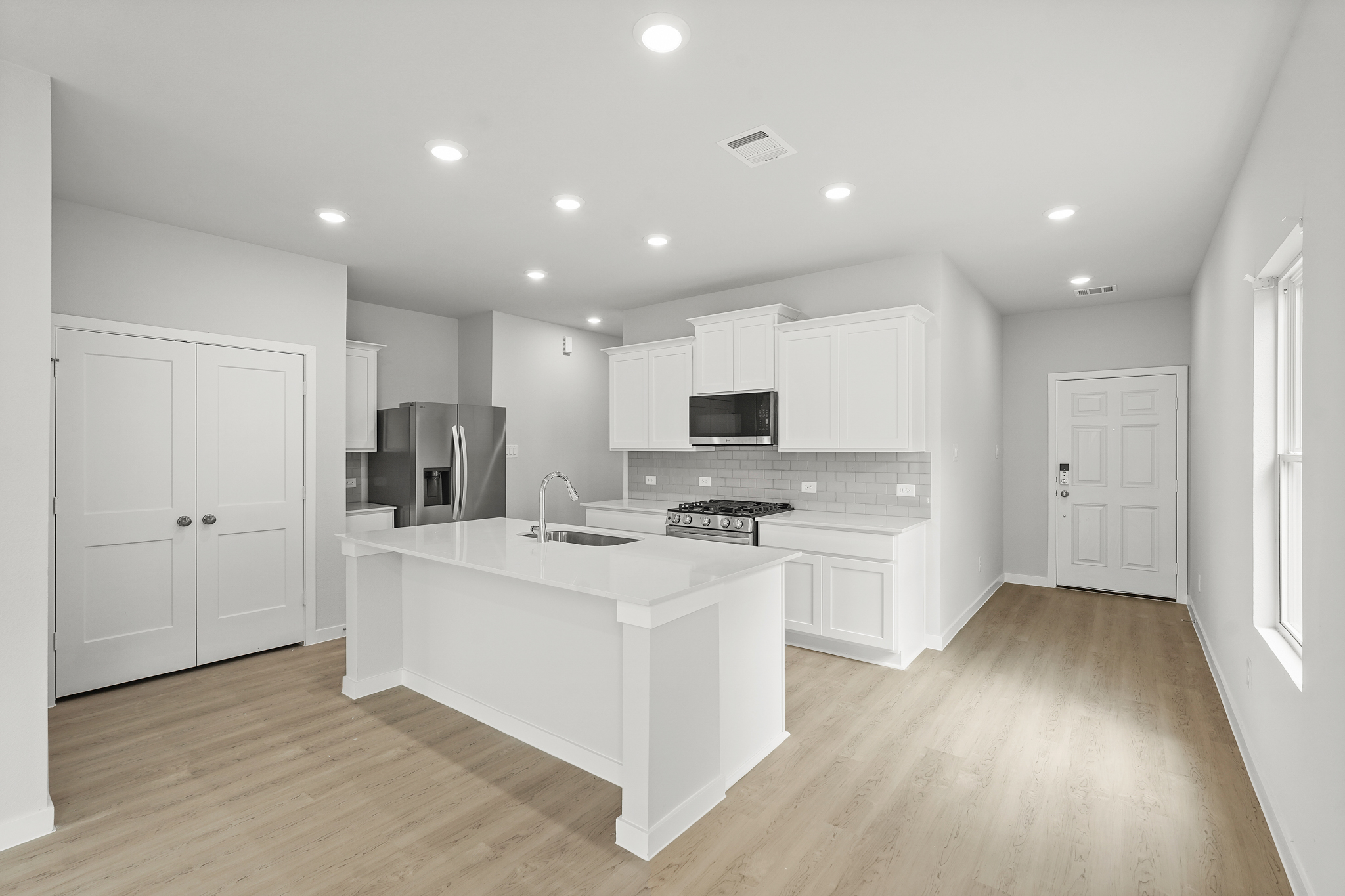 A kitchen with white cabinets.